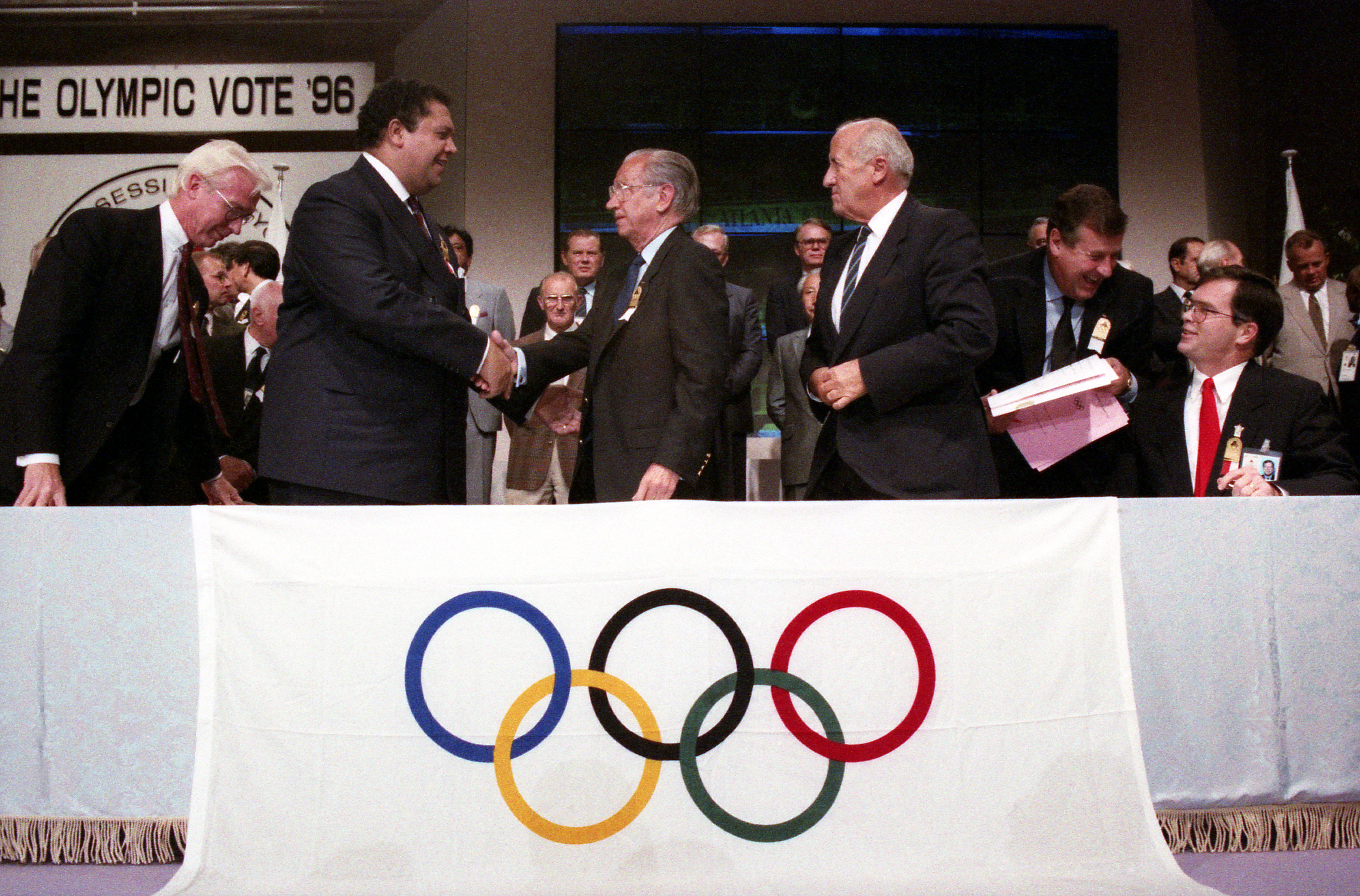 Mayor Maynard Jackson shakes the hand of Juan Samara after winning the Olympic bid, on Sept. 18, 1990. At right is Atlanta Organizing Committee President Billy Payne. AJC File / W.A. Bridges Jr.