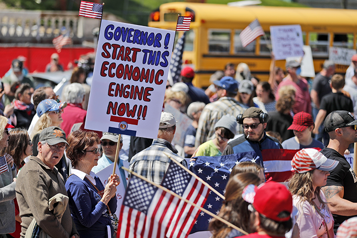A woman holds a sign as she attends a rally outside the Missouri Capitol to protest stay-at-home orders put into place due to the COVID-19 outbreak. Several hundred people attended the rally to protest the restrictions and urge the reopening of businesses closed in an effort to slow the spread of the coronavirus.