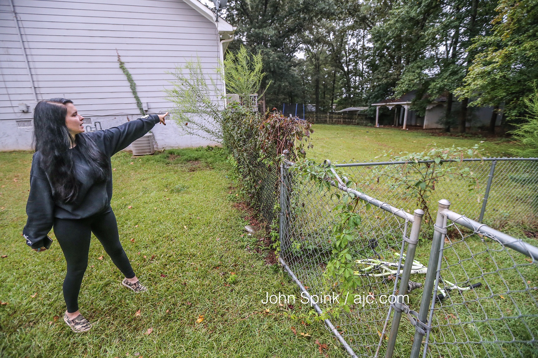 Brittney Speck points to the area where her dog was attacked by a tiger on the loose in Henry County. JOHN SPINK / JSPINK@AJC.COM