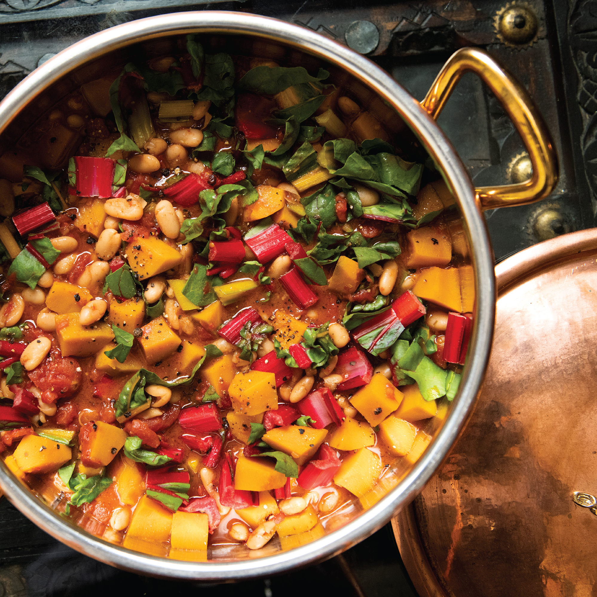 Rainbow Chard and Kabocha Pumpkin Bean Soup is so filling, flavorful, and full of nutritional goodness that even a carnivore won’t miss the meat. From “I Cook in Color: Bright Flavors From My Kitchen and Around the World” by Asha Gomez and Martha Hall Foose (Running Press, $32.50). (Courtesy of Evan Sung)