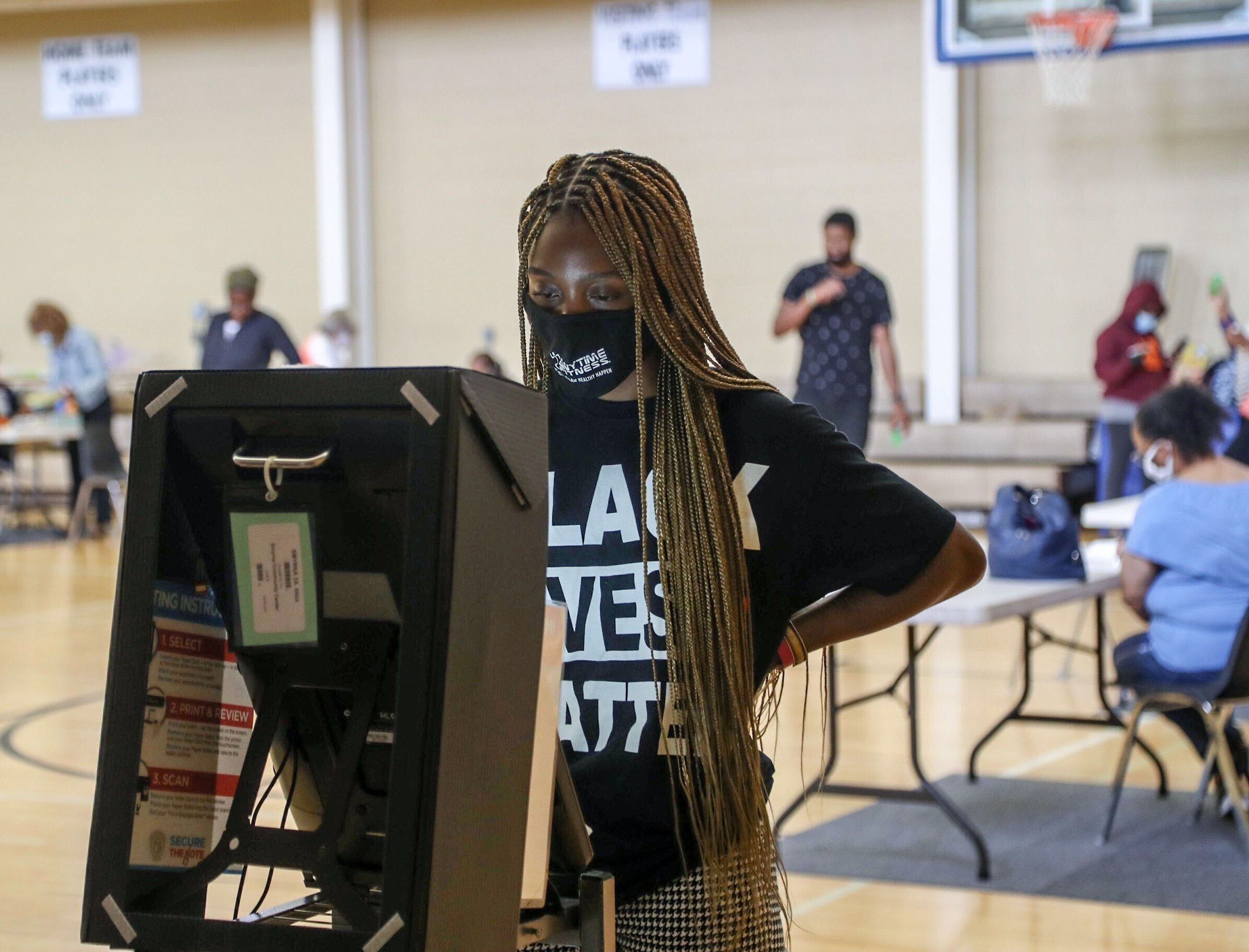 Smyrna resident Courtney Marshall wears a “Black Lives Matter” shirt while using the new electronic voting machine to cast her ballot at the Smyrna Community Center. ALYSSA POINTER / AJC