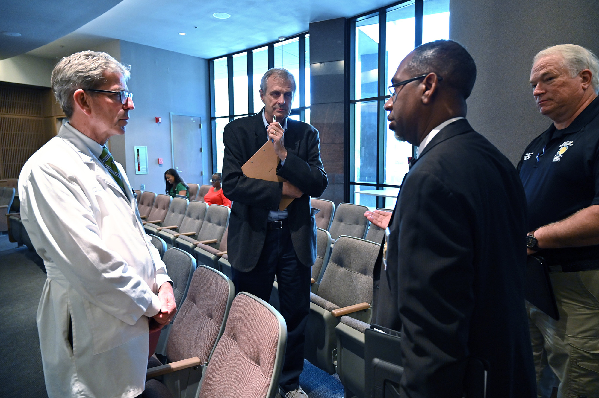 From left, Steven Kitchen, chief medical officer at Phoebe Putney Memorial Hospital, Charles Ruis, district health director at DPH, Dougherty County Coroner Michael Fowler, and Dougherty County EMS Director Sam Allen confer after a press conference to provide a Coronavirus update at Albany Government Center in Albany on Tuesday, March 24, 2020. Well off the interstate some 180 miles south-southwest of Atlanta, Albany's struggles with the Coronavirus stick out like a sore thumb on the state's map, as small towns in the region like Americus and Sylvester reported their first cases of the virus on Friday. (Hyosub Shin / Hyosub.Shin@ajc.com)
