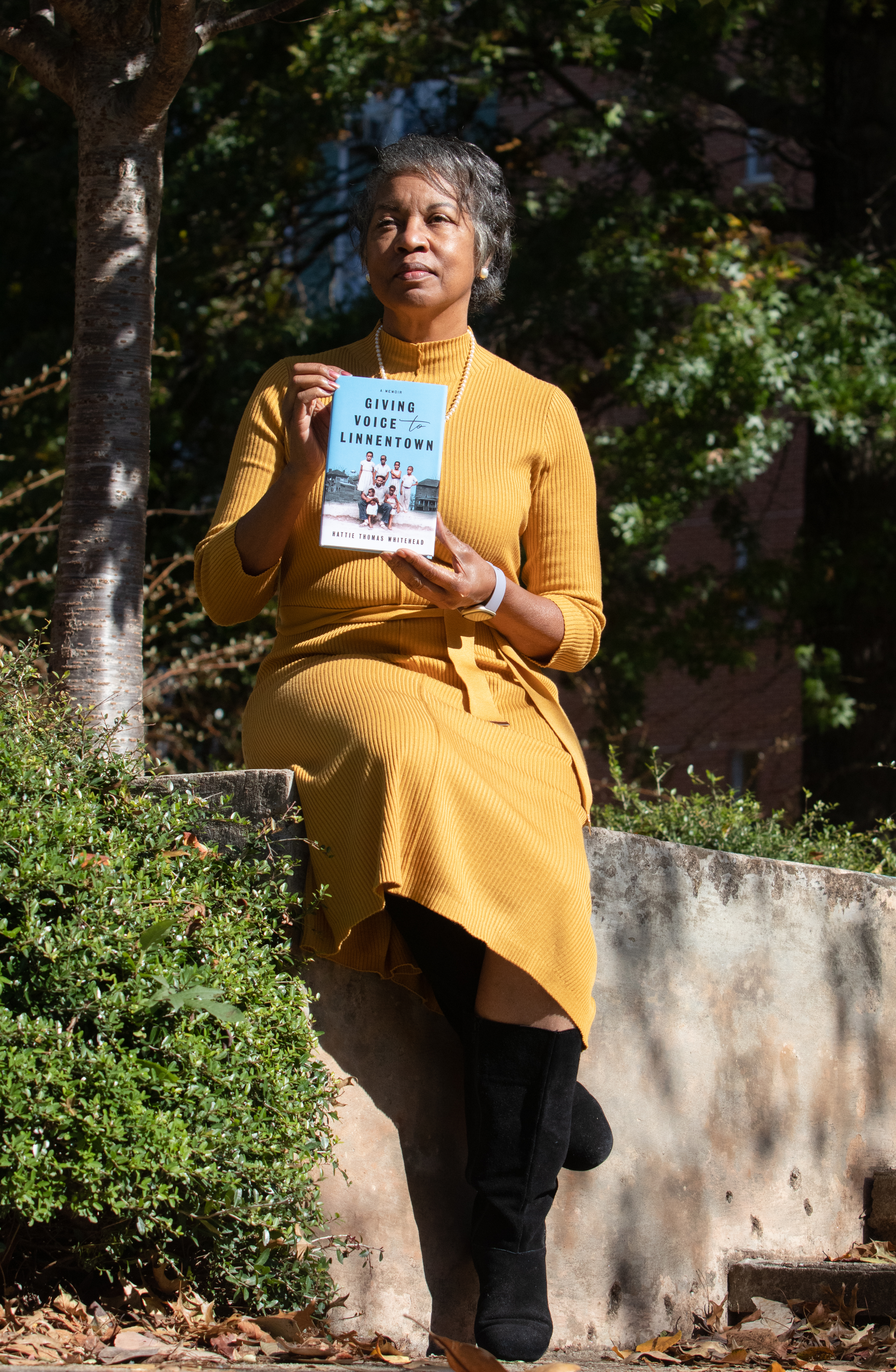 October 18, 2021 - Athens Clarke County - Hattie Whitehead poses with her book, "Giving Voice to Linnentown," outside of Creswell Hall on the University of Georgia campus on Monday, Oct. 18, 2021. Creswell Hall and the surrounding area were once a neighborhood called Linnentown, of which Whitehead is a former resident.
(Sarah White for the Atlanta Journal Constitution)