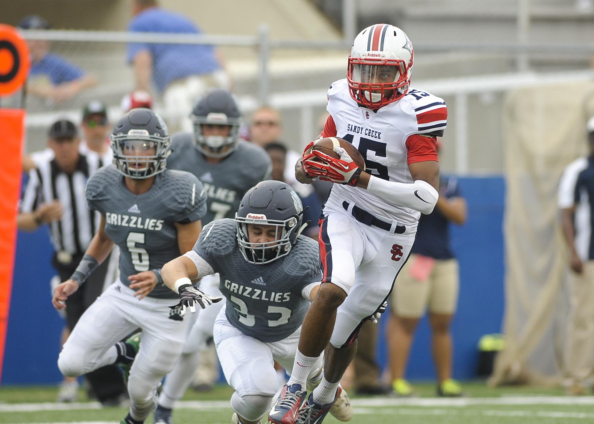Creekview sophomore linebacker Will Michaud tackles Sandy Creek sophomore wide receiver Major Weems (15) in the first half during the Corky Kell Classic at McEachern's Walter H. Cantrell Stadium on Aug. 21, 2015. (Daniel Varnado/Special to the AJC)