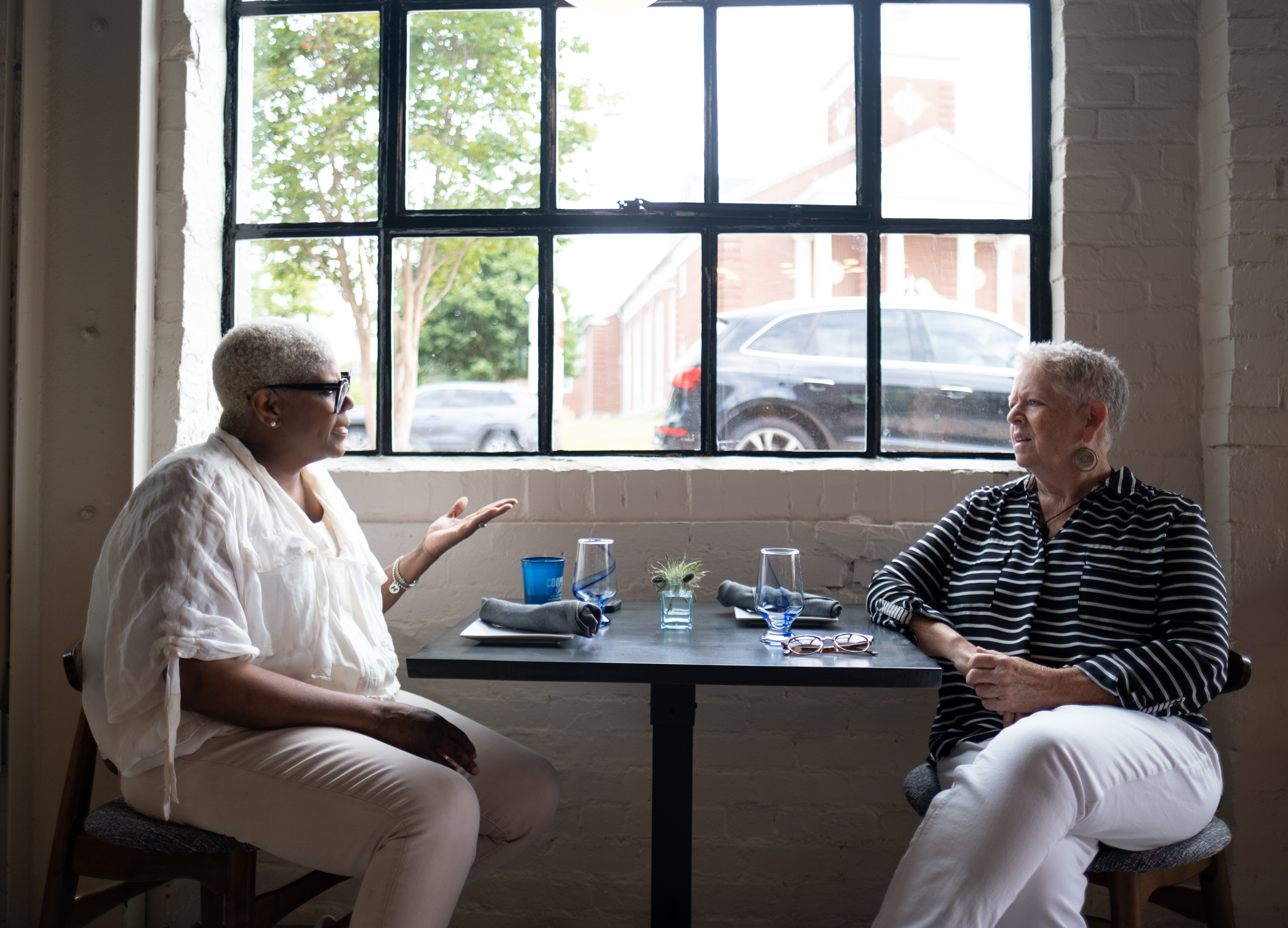 Oreatha’s at the Point co-owners Deborah VanTrece, left, and Shea Embry chat before the restaurant opens for brunch. Ben Gray for the Atlanta Journal-Constitution