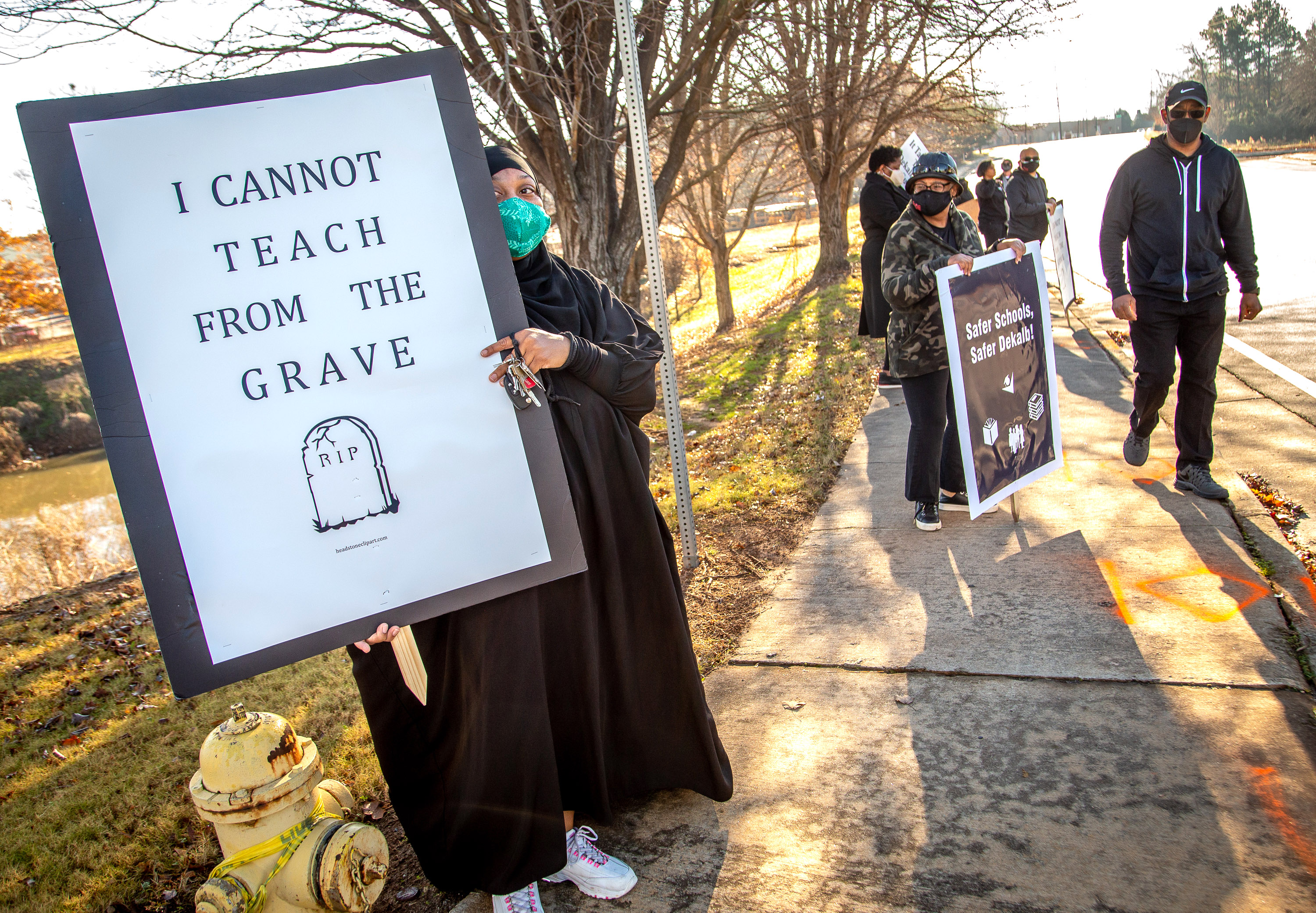 Teacher Amber Horton holds up a sign during a protest in front of the DeKalb school district offices along Mountain Industrial Boulevard in Stone Mountain on Tuesday, Dec. 29, 2020. STEVE SCHAEFER FOR THE ATLANTA JOURNAL-CONSTITUTION