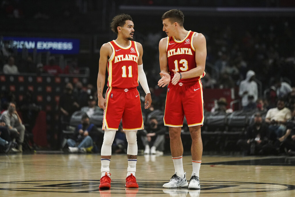 Atlanta Hawks' Trae Young, left, talks with Bogdan Bogdanovic during first half of an NBA basketball game against the Los Angeles Clippers Sunday, Jan. 9, 2022, in Los Angeles. (AP Photo/Jae C. Hong)