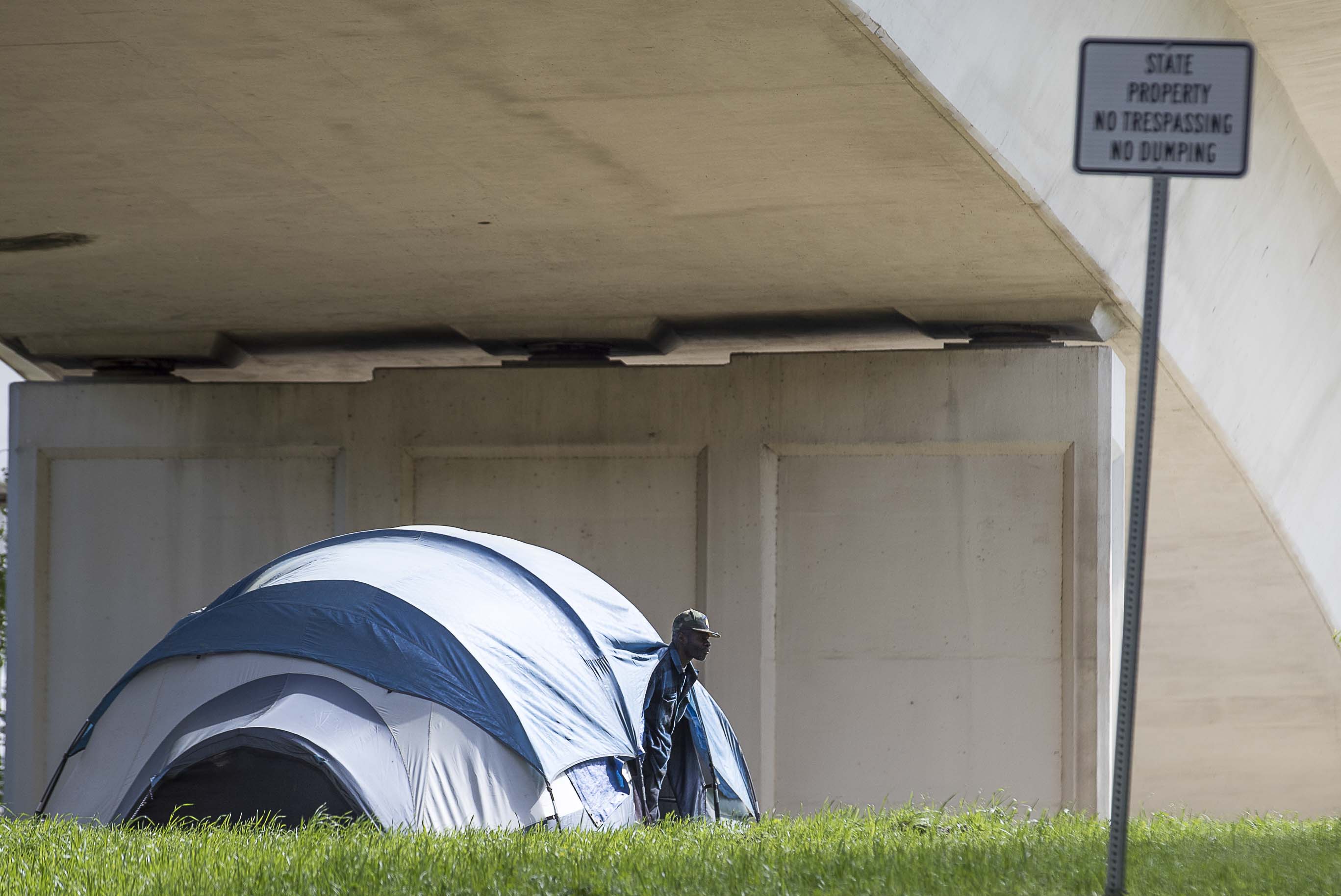 04/01/2020 - Atlanta, Georgia - A man peeks out of his tent located below an interstate underpass on Pryor Street SW in Atlanta, Wednesday, April 1, 2020. "Tent-Cities" are popping back up due to homeless shelters at capacity or that are refusing intake due to coronavirus. (ALYSSA POINTER / ALYSSA.POINTER@AJC.COM)