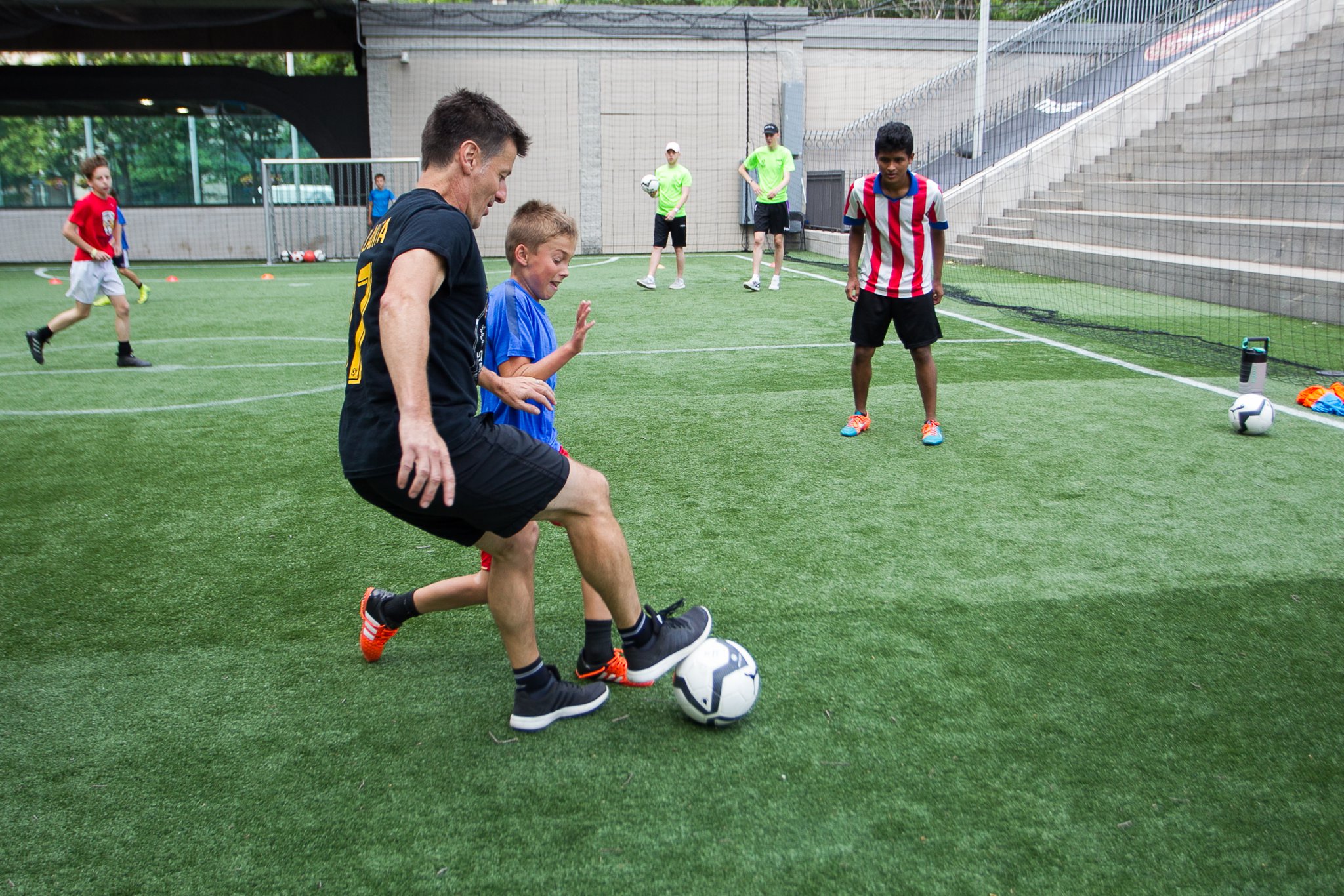 Phil Hill, executive director of Soccer in the Streets, mixes it up with kids at a summer camp at the Five Points MARTA Station.