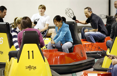 It's a lacrosse-like game. The object is to work a wiffle ball down a court using plastic scoops and score in the opposing team's goal, a nine-foot-high backboard with a hole in the middle. The game is played in special bumper cars known as whirlybugs. Yuting Cheng, center, battles fellow employees from Credigy, a financial services business, for the ball from her bumper car during a team building outing at Whirlyball Atlanta.