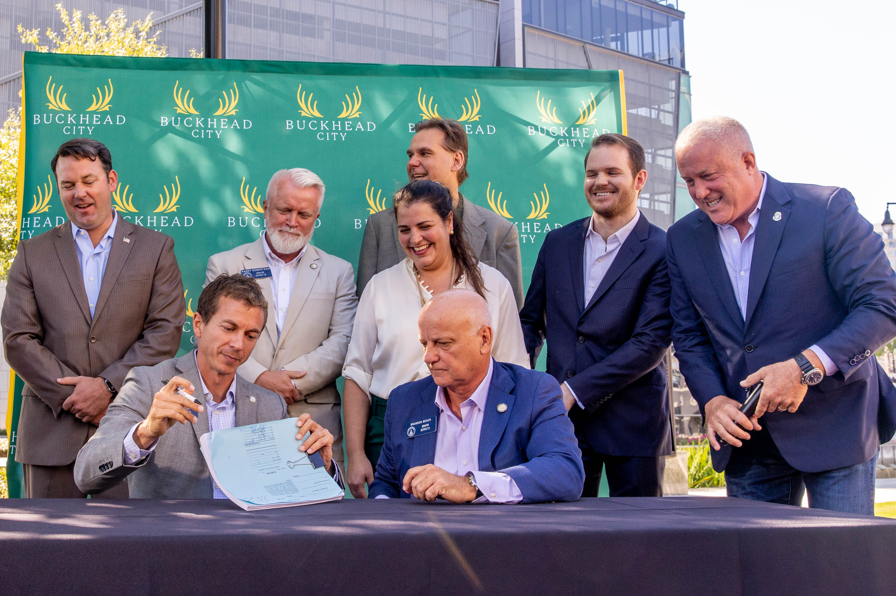 Buckhead City supporters, local residents and several state senators, including Greg Dolezal, seated, signed the bill in support of the city onsite, illustrating support in the state Senate, with the bill’s writer Senator Brandon Beach, seated right, at Loudermilk Park on Wednesday, Sept 29, 2021. The group announced that during the upcoming special legislative session the bill will be discussed. (Jenni Girtman for The Atlanta Journal-Constitution)