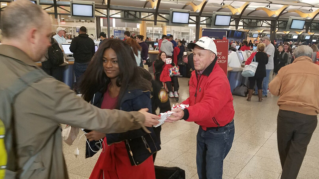 Chick-fil-A owner and CEO Dan Cathy hands out sandwiches to passengers stranded overnight at Hartsfield-Jackson Atlanta International Airport. The Atlanta-based chicken chain donated more than 5,300 sandwiches to feed hungry travelers. Photo credit: Chick-fil A
