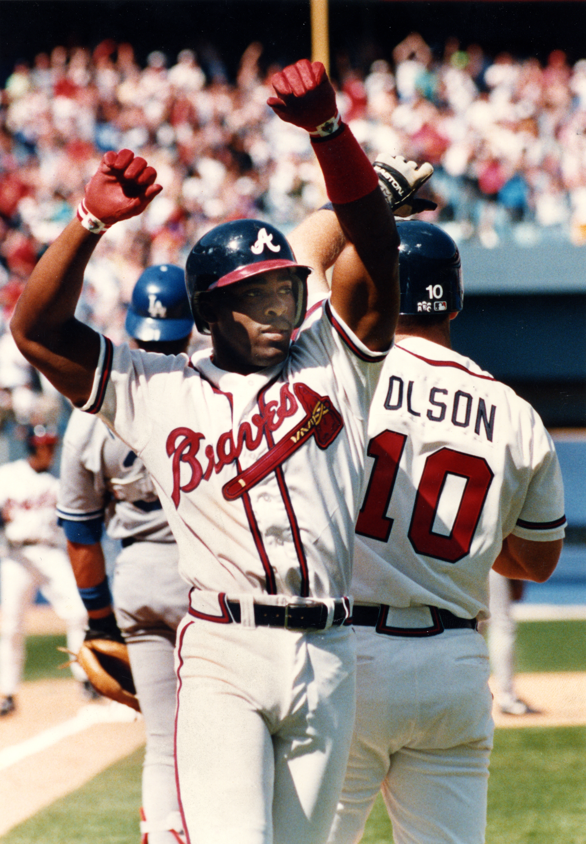 Atlanta Braves runner Ron Gant safely dives back to the bag as