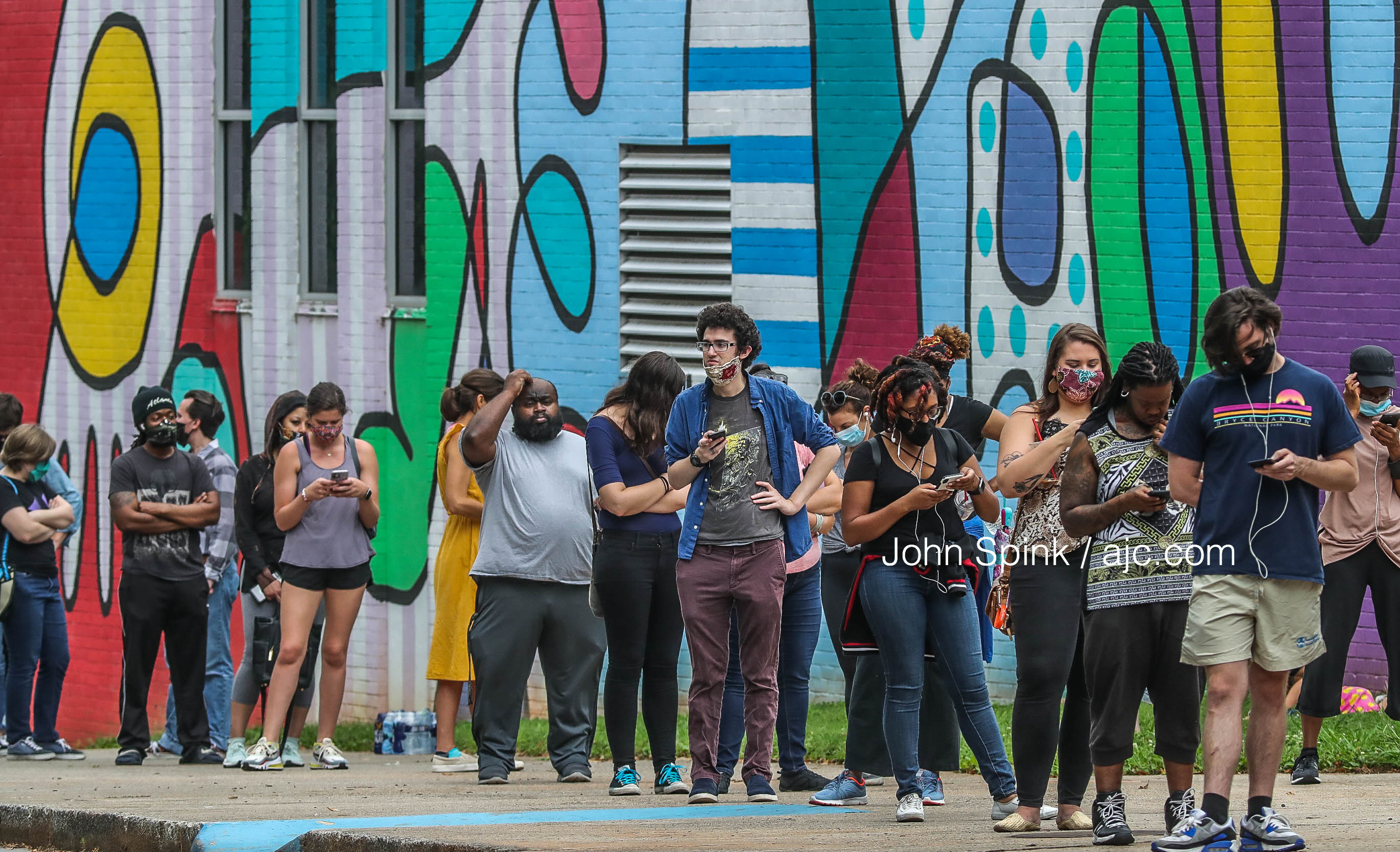 Voters wait in line at Cross Keys High School on Tuesday, June 9, 2020. JOHN SPINK / AJC
