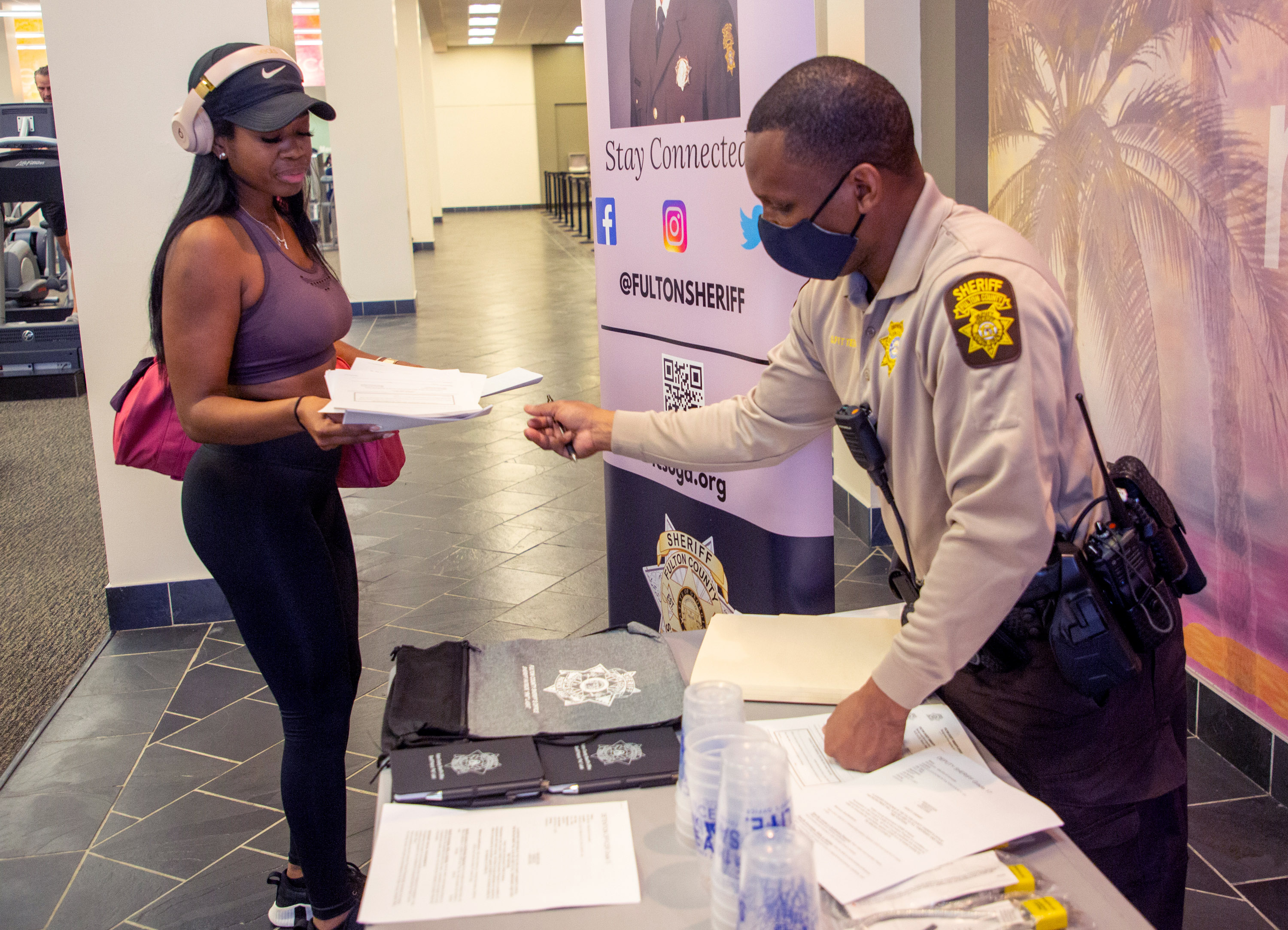 Santrez Fitter gives Kierston Hurst information at a Fulton County Sheriff's Office job fair at LA Fitness in Atlanta Friday, Feb. 11, 2022. STEVE SCHAEFER FOR THE ATLANTA JOURNAL-CONSTITUTION