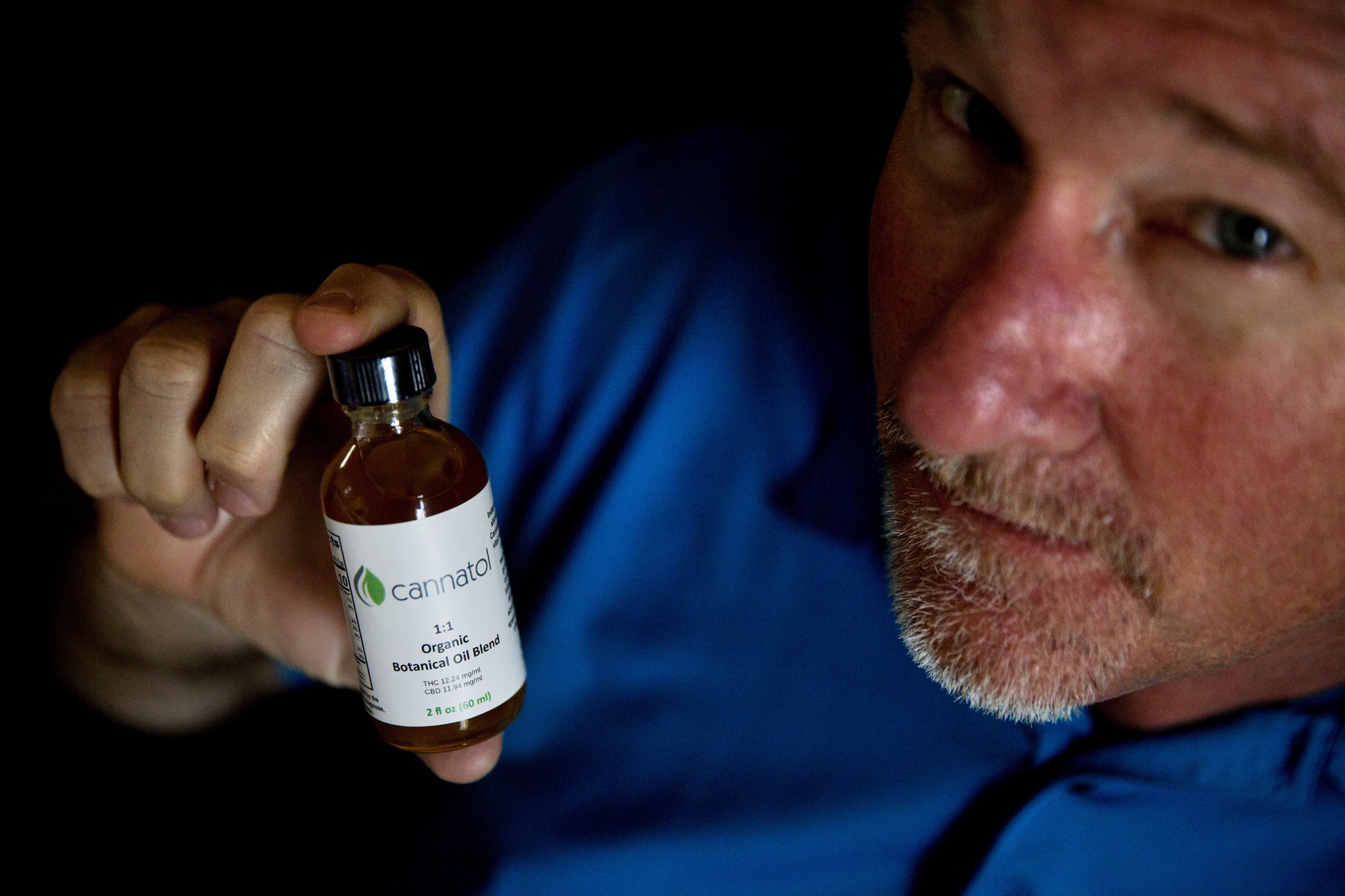 Former Georgia state Rep. Allen Peake, R-Macon, displays a bottle of cannabis oil in his office in Macon. (AP Photo/David Goldman)