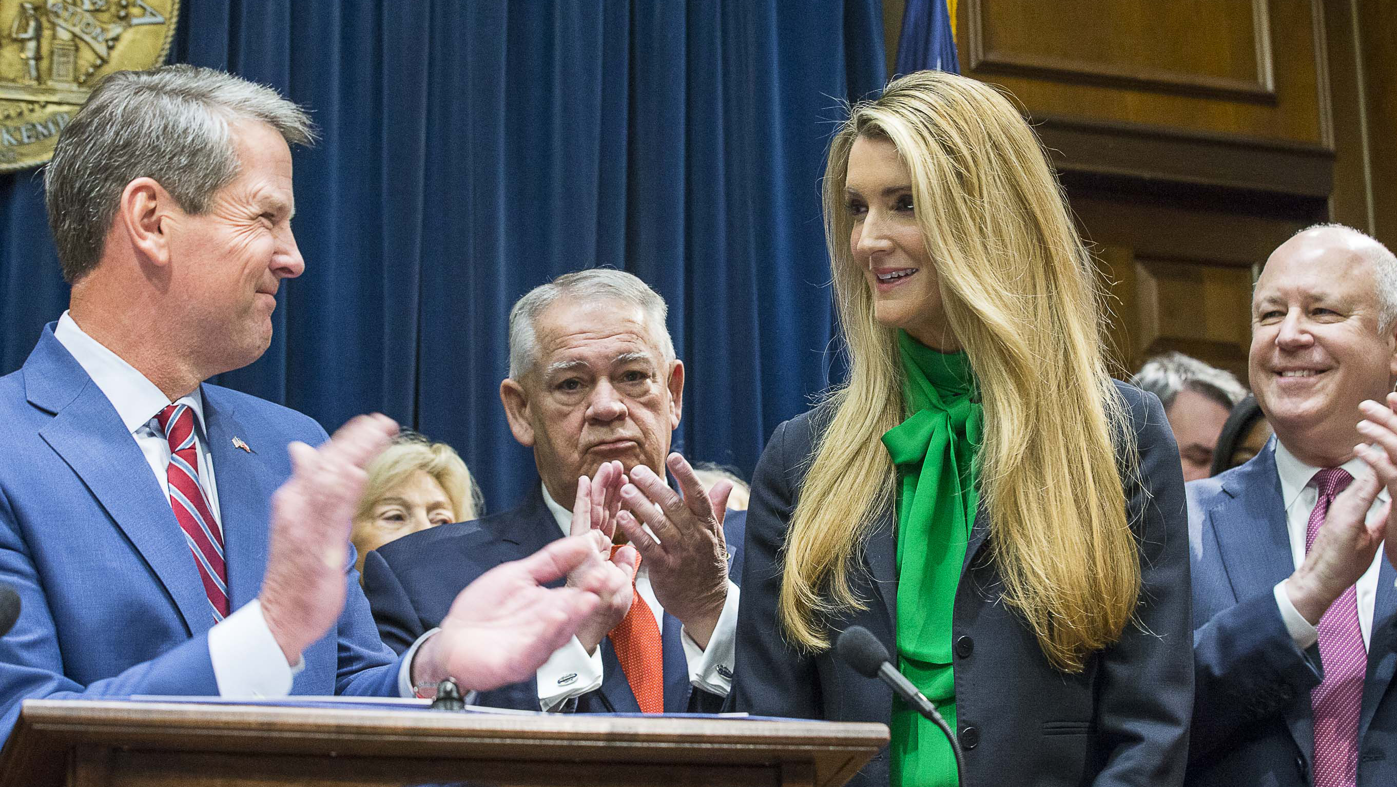 12/04/2019 -- Atlanta, Georgia -- Lawmakers applaud as newly appointed U.S. Senator Kelly Loeffler (second from right) is introduced by Georgia Gov. Bria Kemp (left) during a press conference in the Governor's office at the Georgia State Capitol Building, Wednesday, December 4, 2019. Georgia Gov. Brian Kemp appointed Kelly Loeffler to the U.S. Senate to take the place of U.S. Senator Johnny Isakson, who is stepping down for health reasons. (ALYSSA POINTER/ALYSSA.POINTER@AJC.COM)