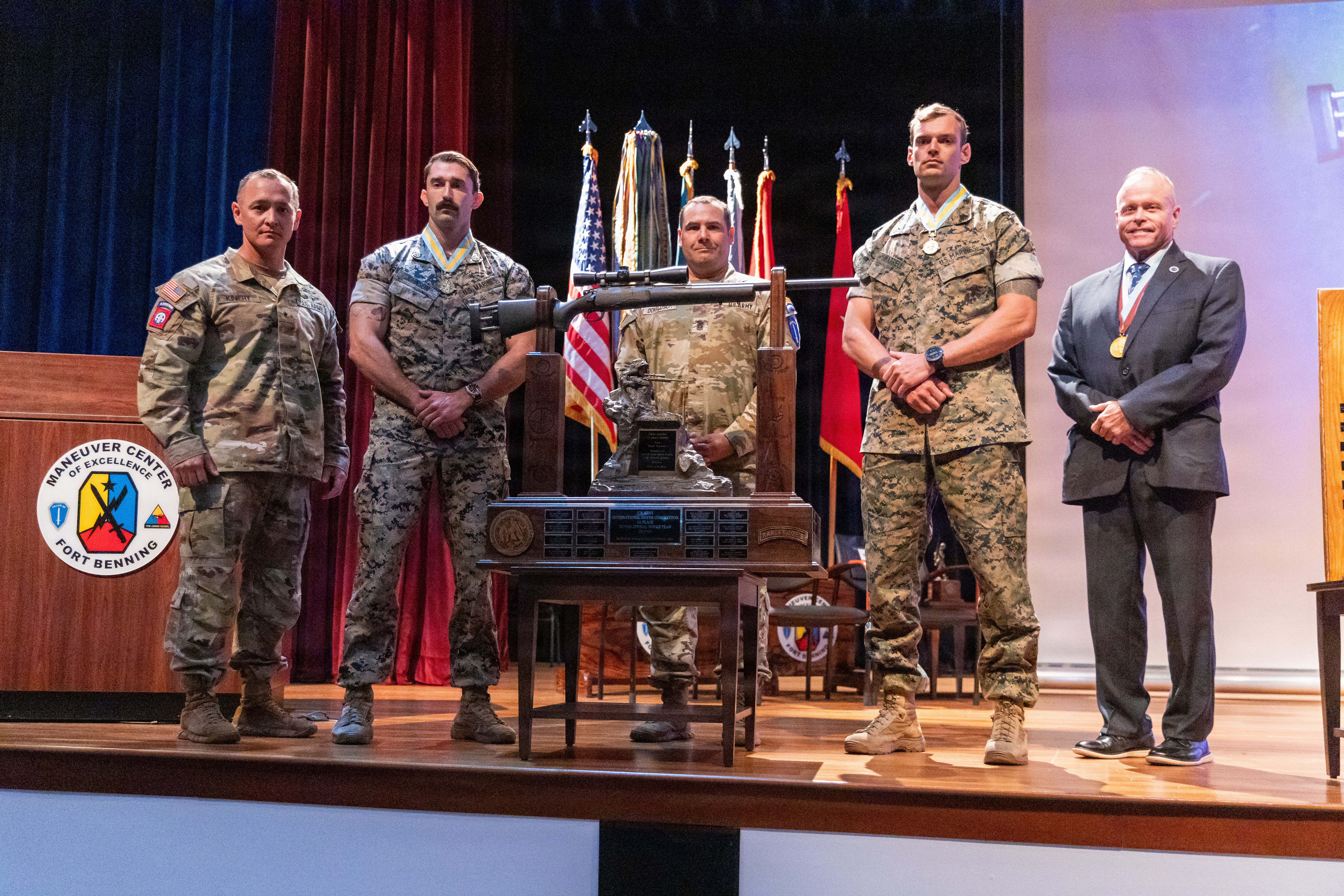 Two Marine snipers in ghillie suits aiming rifles