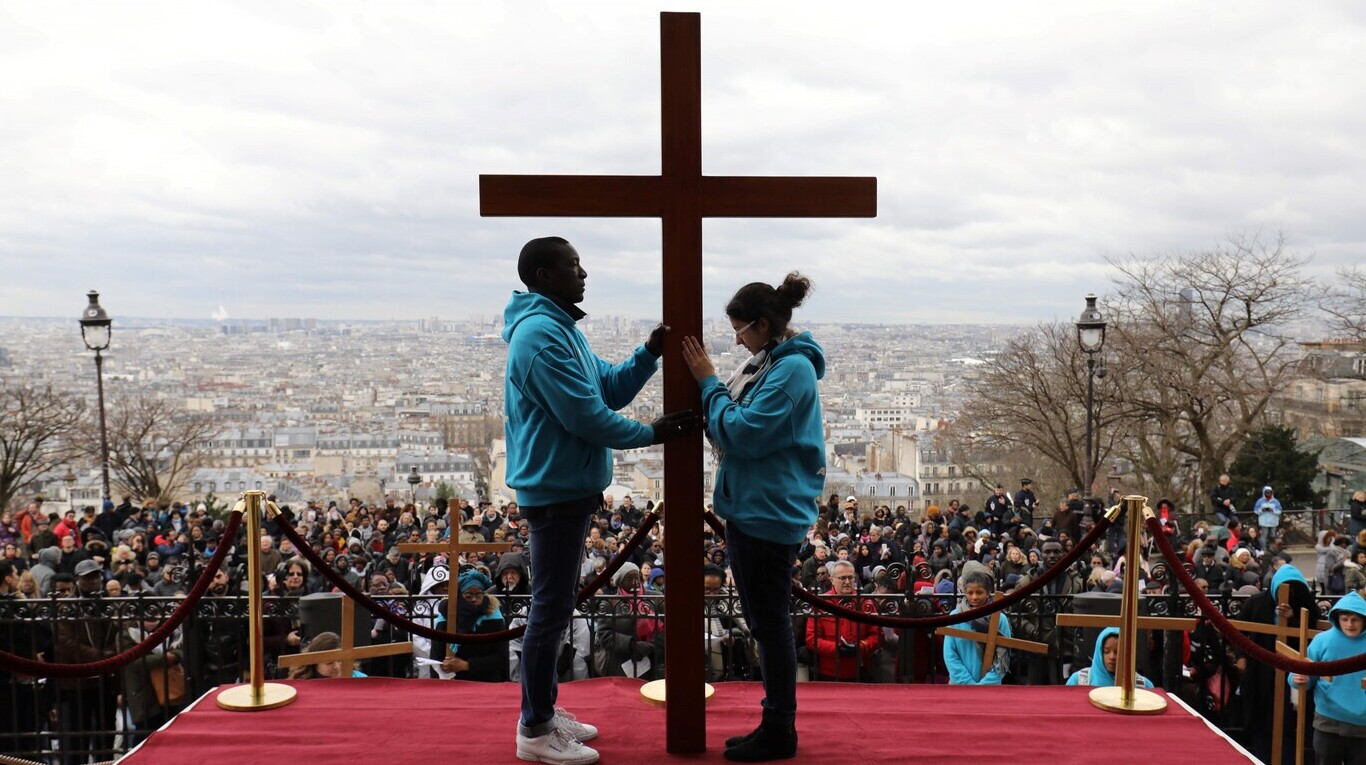 Personas sosteniendo una cruz durante una procesión del Vía Crucis, frente a la Basílica de Sacre Coeur, en París. (Foto: Ludovid Marin/AFP)