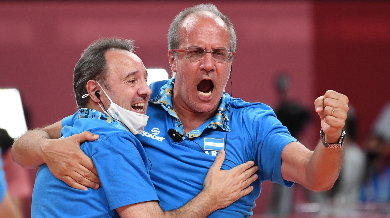 Los entrenadores argentinos Eduardo Dileo (L) y Marcelo Méndez (R) celebran su victoria en el partido de voleibol de cuartos de final masculino entre Italia y Argentina durante los Juegos Olímpicos de Tokio 2020 en el Ariake Arena de Tokio el 3 de agosto de 2021 (Yuri Cortez/ AFP)
