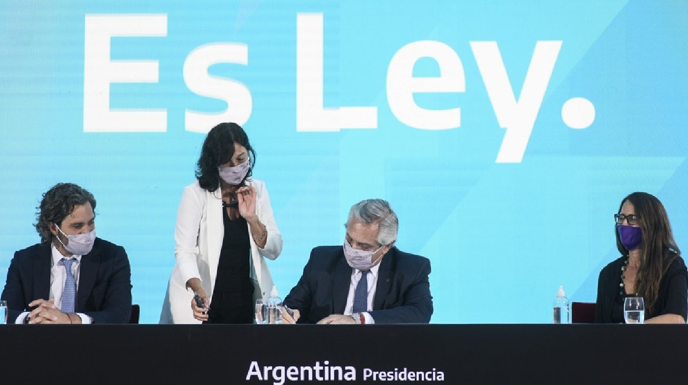 Otros tiempos. Alberto Fernández firma el acta de promulgación de la ley 27.610 de IVE. (Foto: Télam)