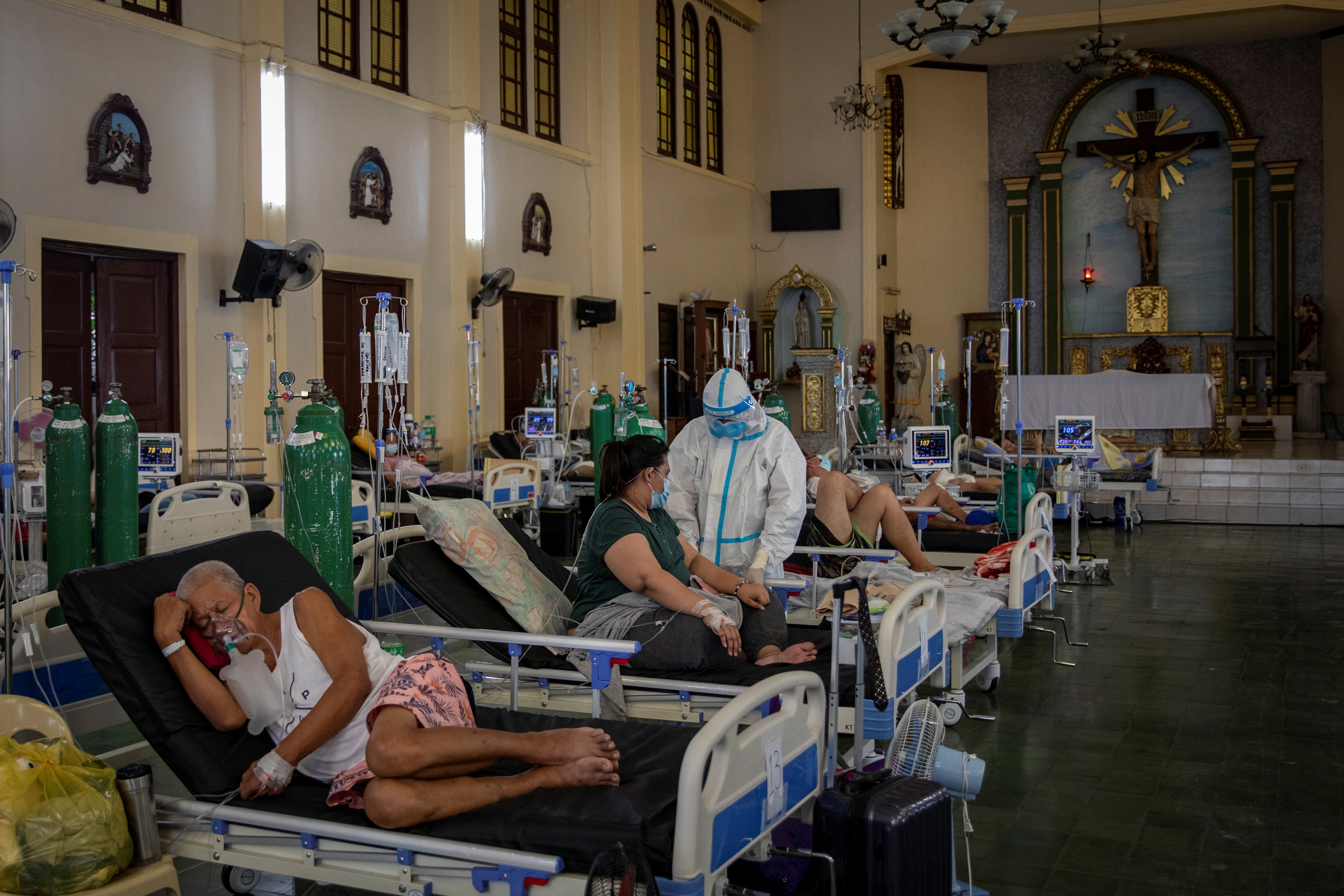 Personal de salud atiende a personas graves con covid en la capilla del Hospital General de Quezon, en Filipinas. (Foto: Reuters)