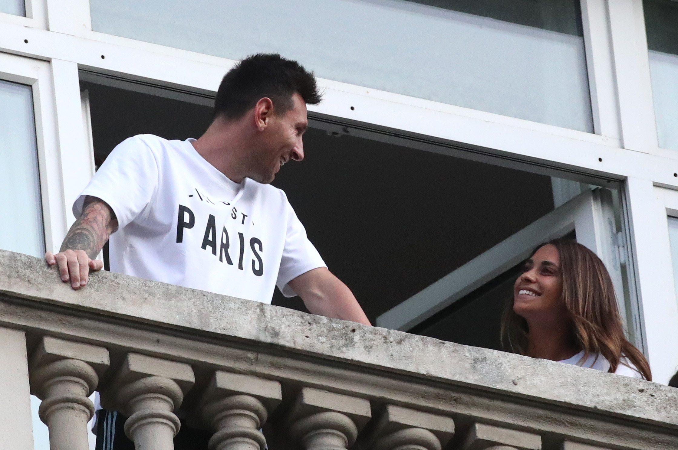 Soccer Football - Lionel Messi arrives in Paris to join Paris St Germain - Paris, France - August 10, 2021  Lionel Messi is seen with his wife Antonela from the balcony of the Royal Monceau Hotel REUTERS/Yves Herman