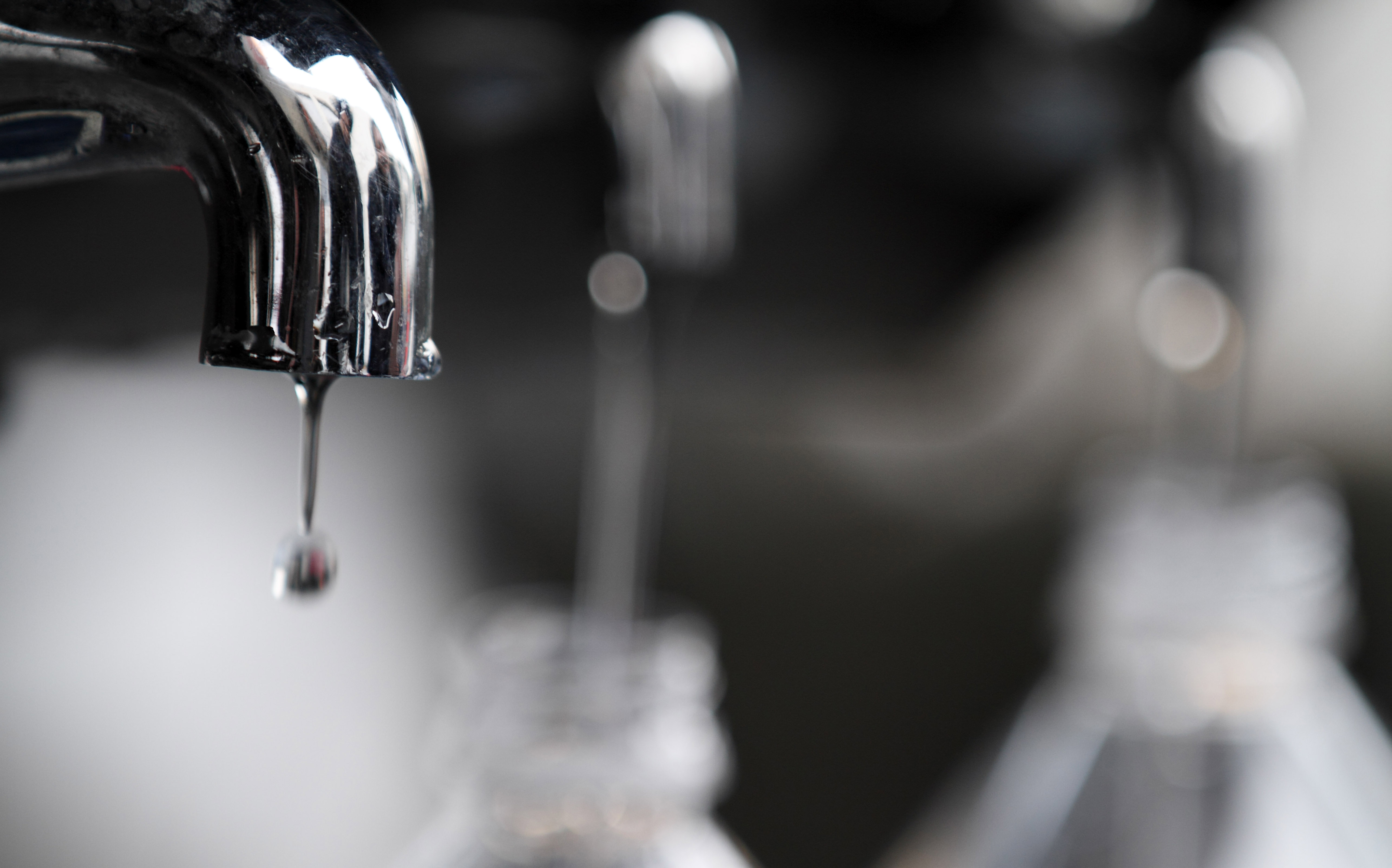 Water drips from a faucet as water bottles are filled at an emergency center on Sunday, March 13, 2011, in Koriyama, Japan, two days after a giant quake and tsunami struck the country's northeastern coast.