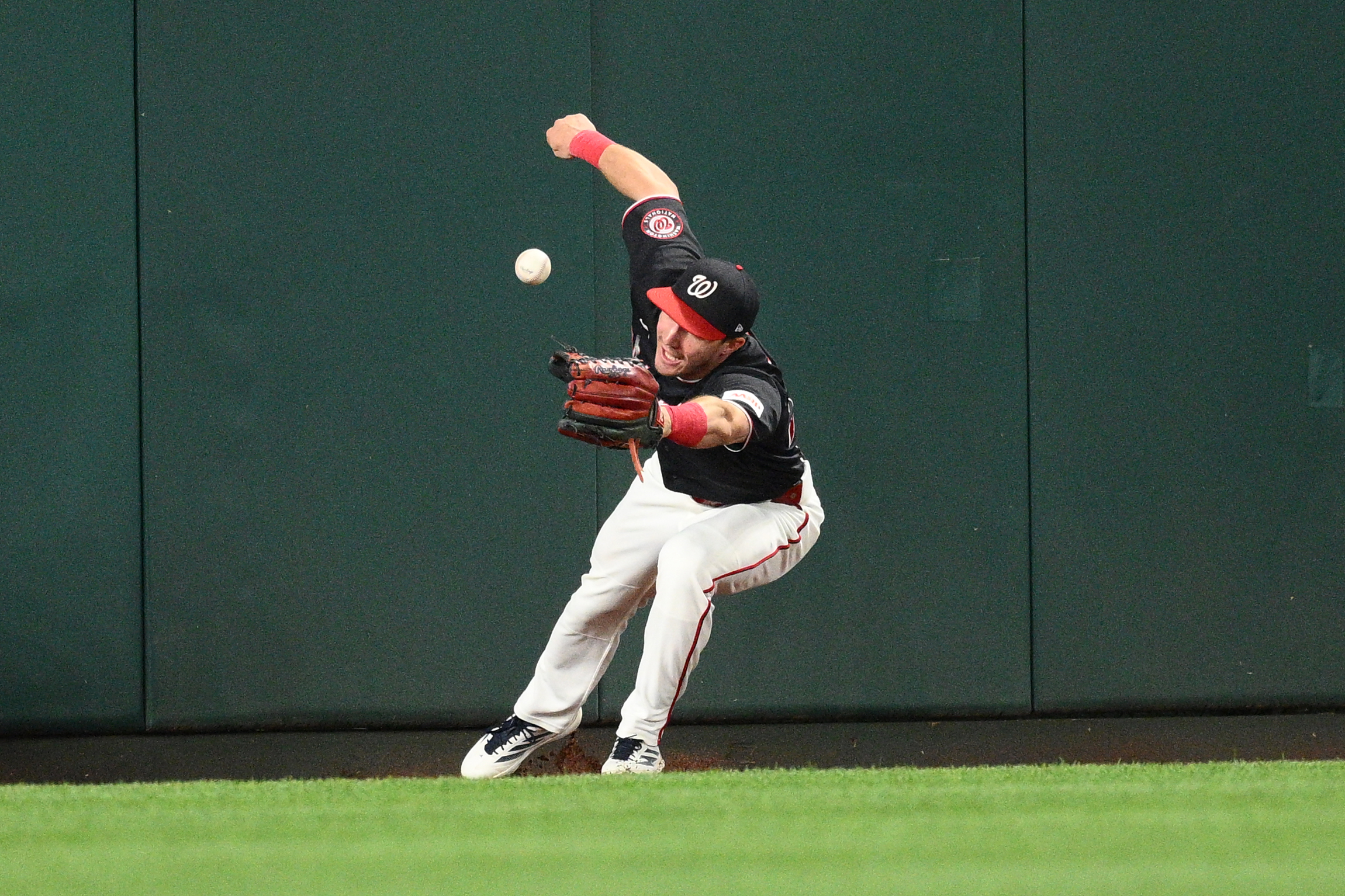 Washington Nationals center fielder Jacob Young tries to field a ball that went for a triple by Seattle Mariners' Dominic Canzone during the second inning of a baseball game, Friday, June 12, 2026, in Washington.