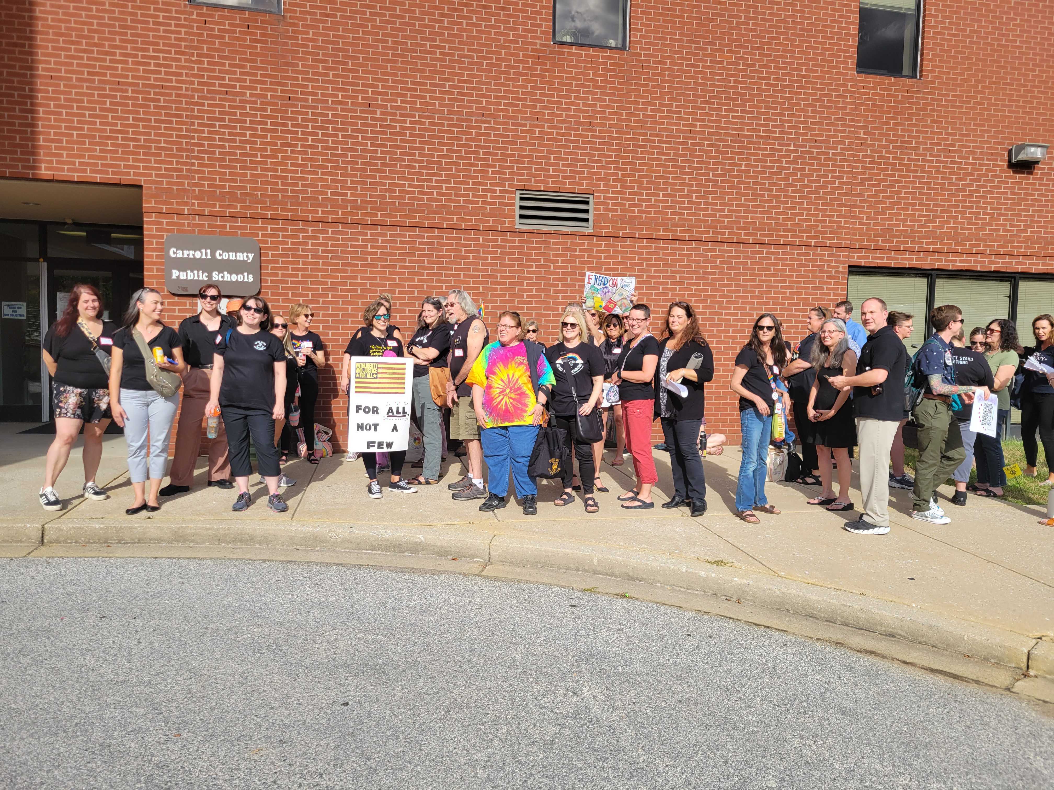 People wear black in opposition to the Carroll County superintendent's decision to remove 56 books from school libraries until a committee reviews them.