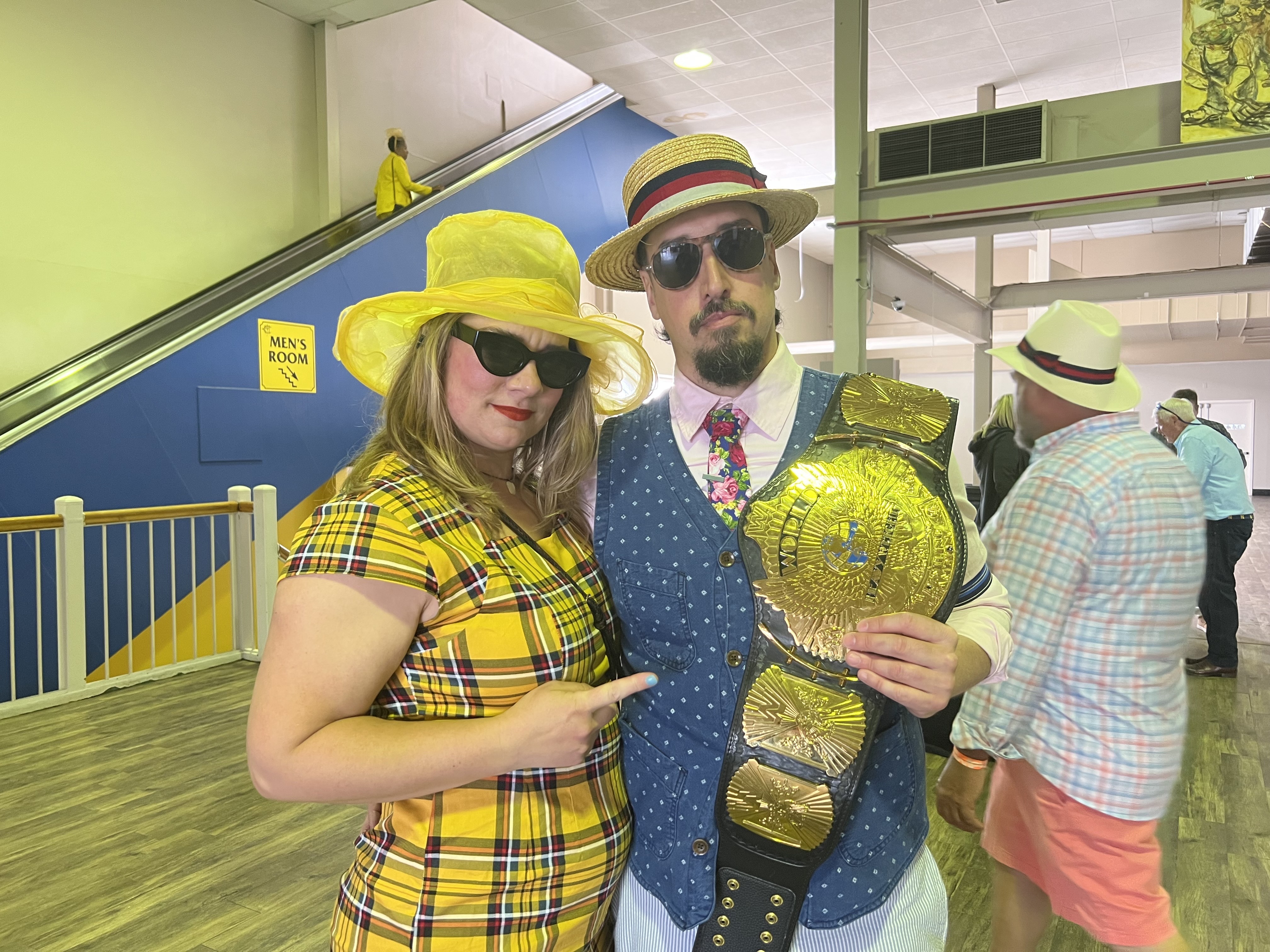 Two fans enjoy Preakness with a wrestling championship belt. (Cadence Quaranta/The Baltimore Banner)