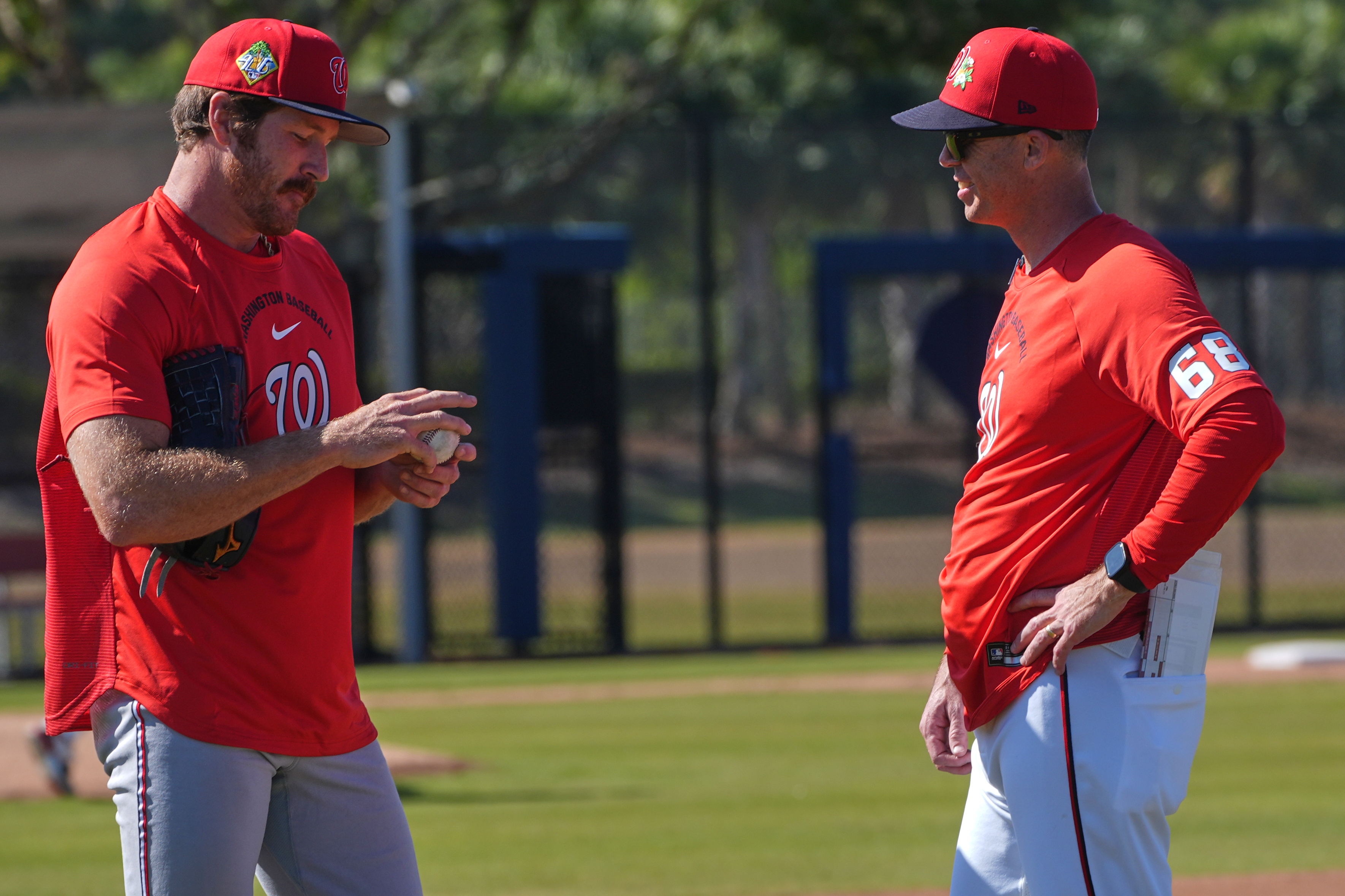 Washington Nationals pitcher Miles Mikolas talks to bullpen coach Dustin Glant (68) during a spring training practice in February.