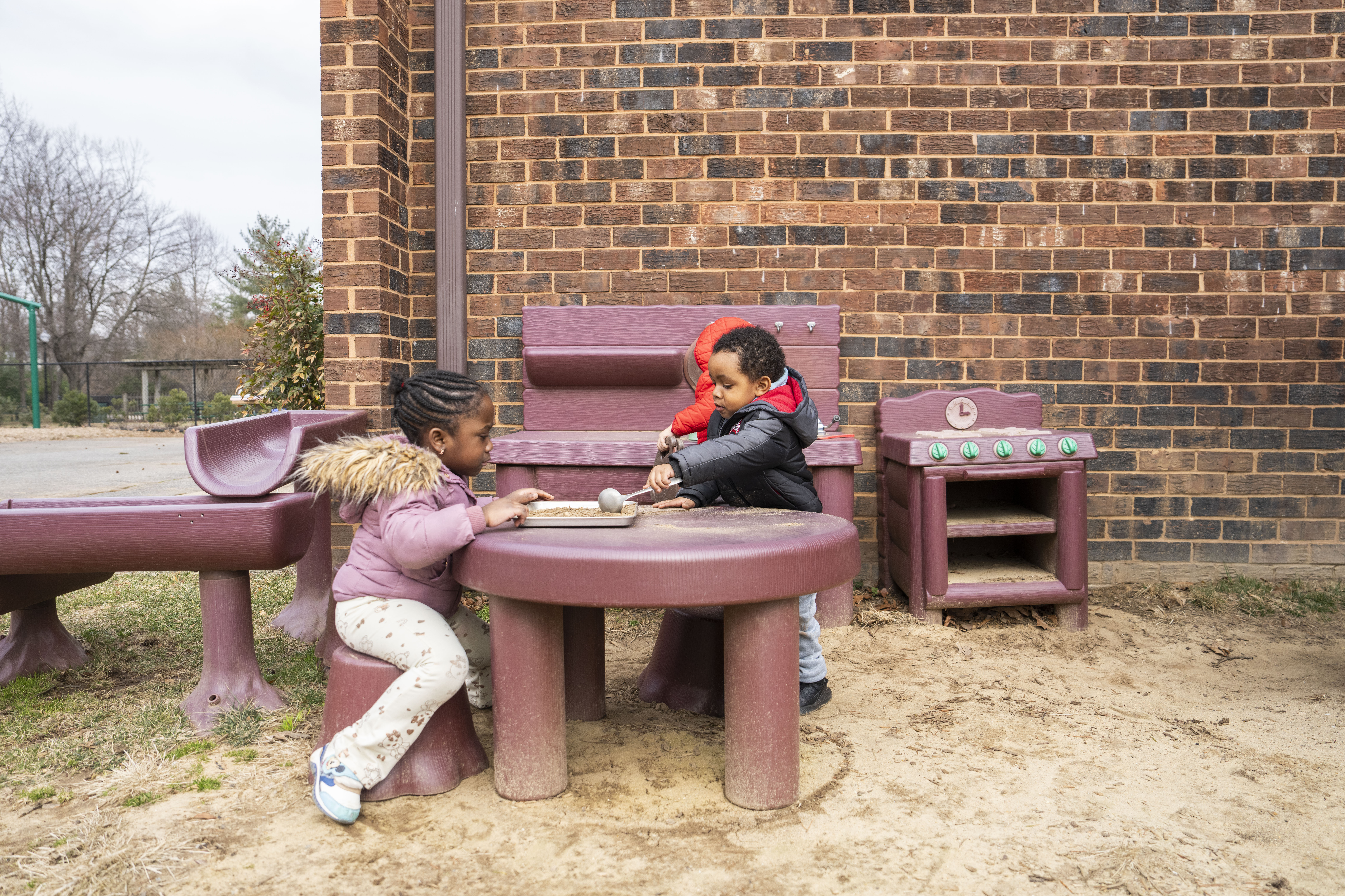 Students take advantage of the nice weather and play outside in the sandbox and on the playground at Greenbelt Children's Center on February 25, 2025.