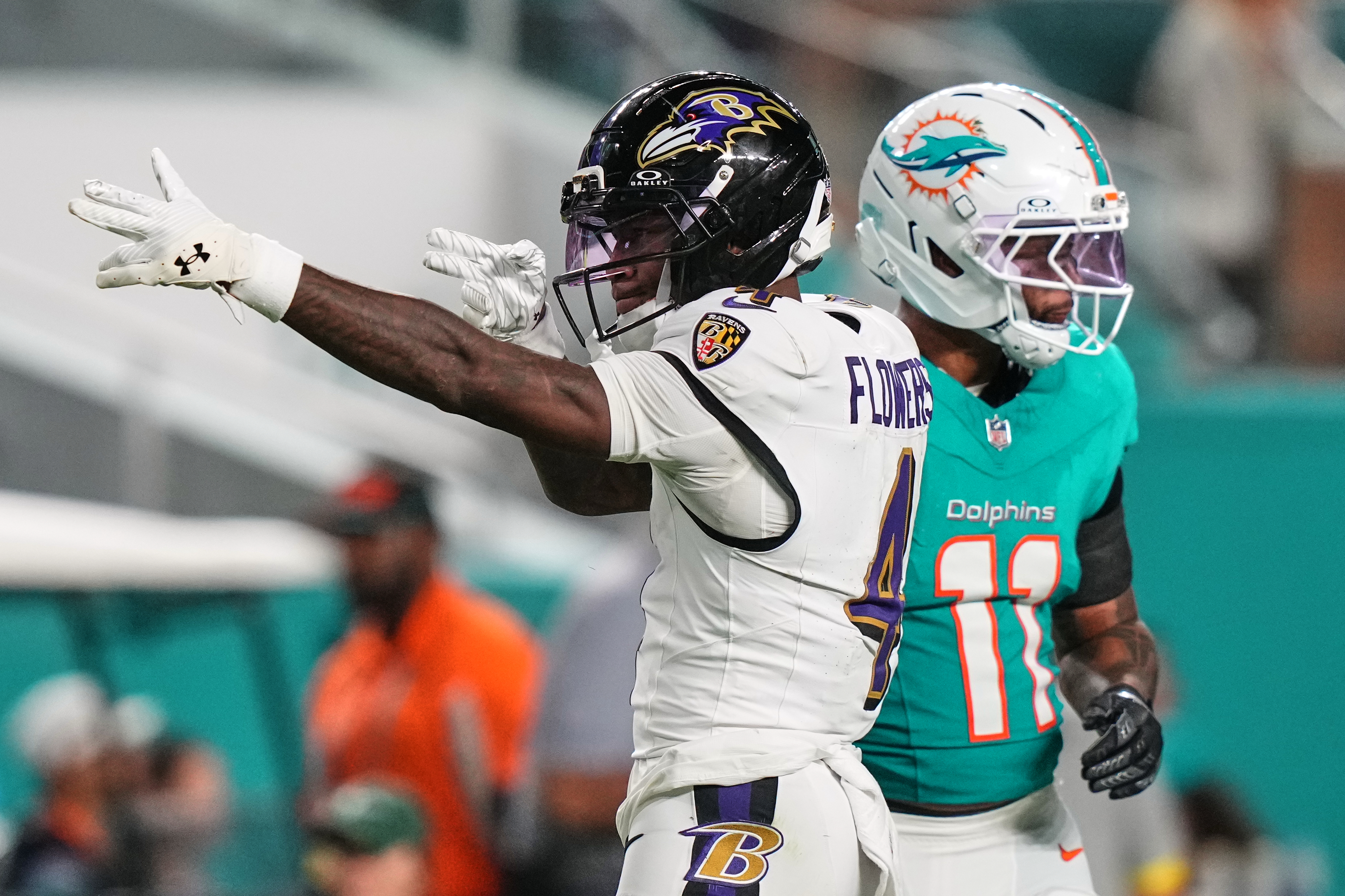 Baltimore Ravens wide receiver Zay Flowers (4) celebrates next to Miami Dolphins safety Dante Trader Jr. (11) after a 39-yard reception for a first down during the second half of an NFL football game, Thursday, Oct. 30, 2025, in Miami Gardens, Fla.