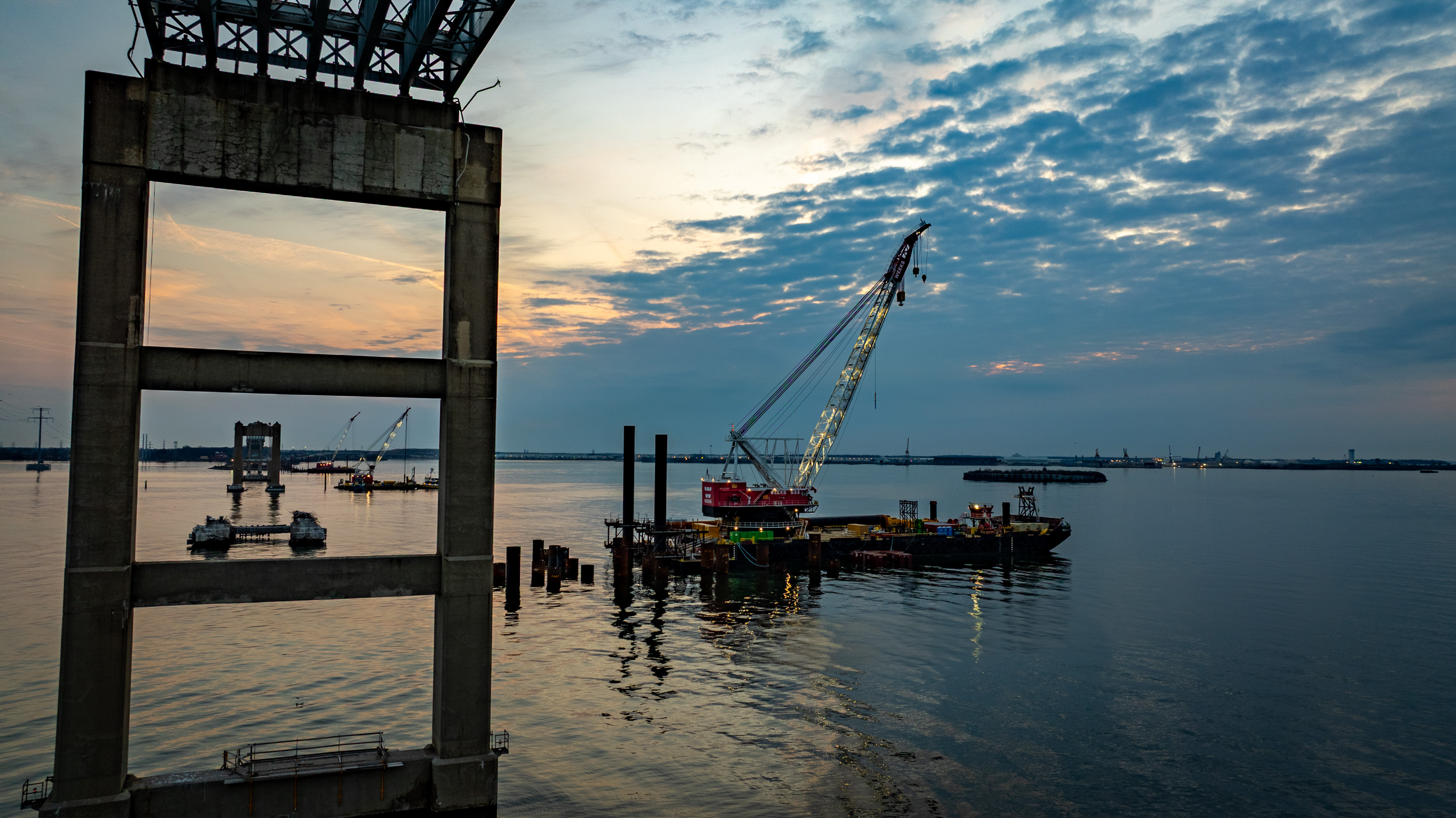 Crane barges are idle at sunrise at the Francis Scott Key Bridge site on the second anniversary of its catastrophic collapse.
