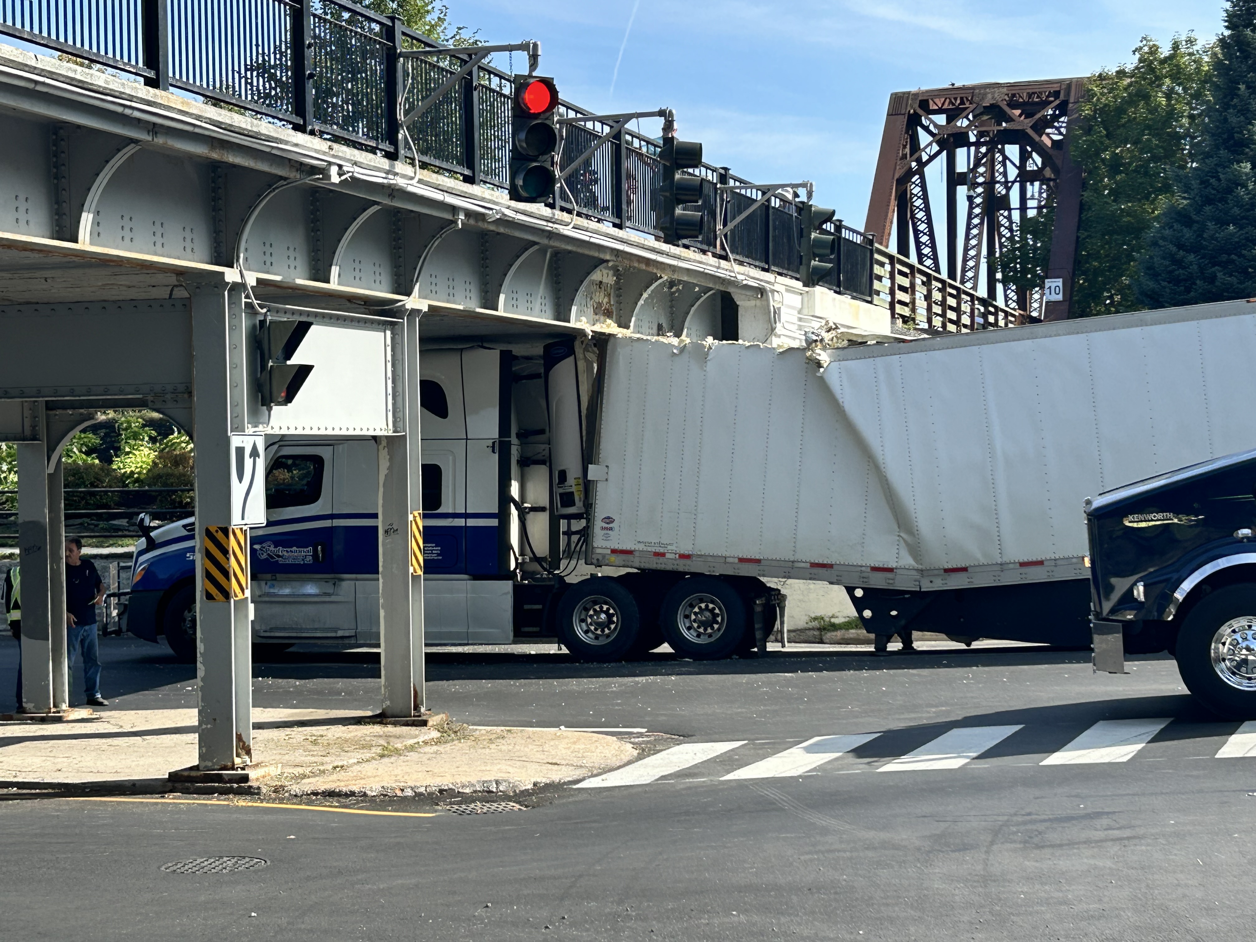 Transport truck full of alcohol gets stuck under Fredericton overpass