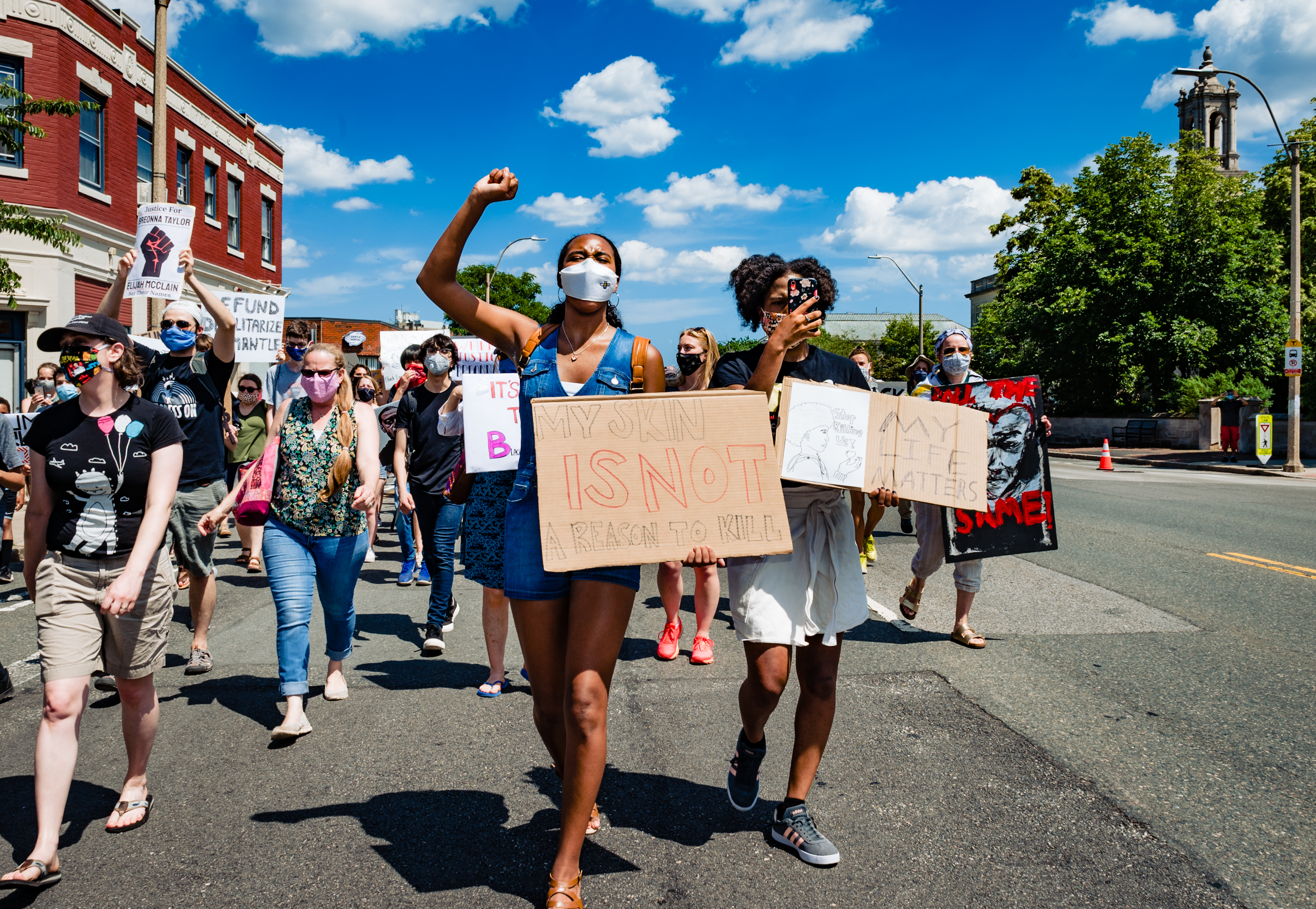 Mia Maxwell (center), who is on the Black Student Union counsel for Arlington High School, and her sister Camille Maxwell (right) marched during the protest in Arlington on June 20.