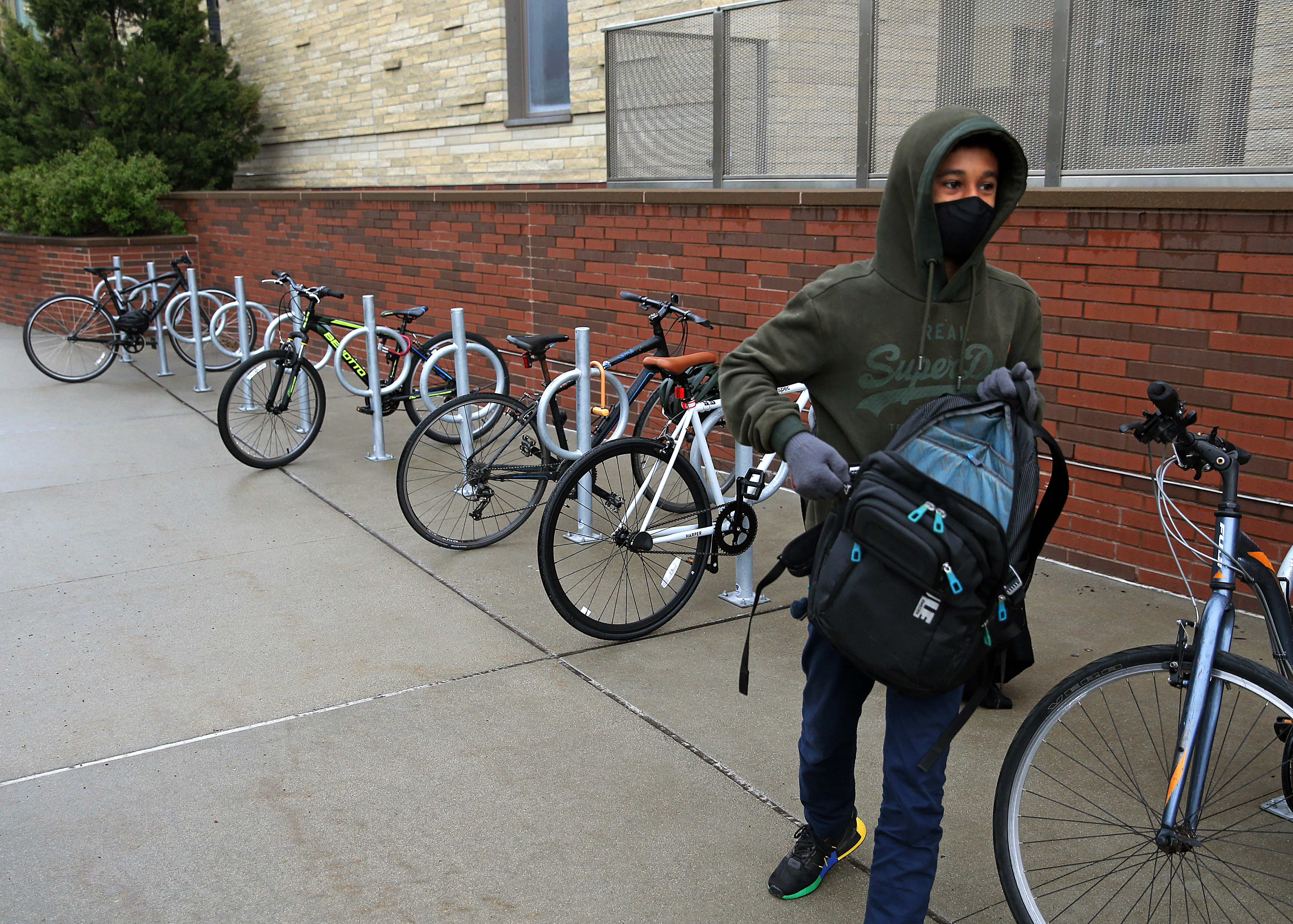 A student arrives after riding his bike to school at the Putnam Avenue Upper School, Cambridge.