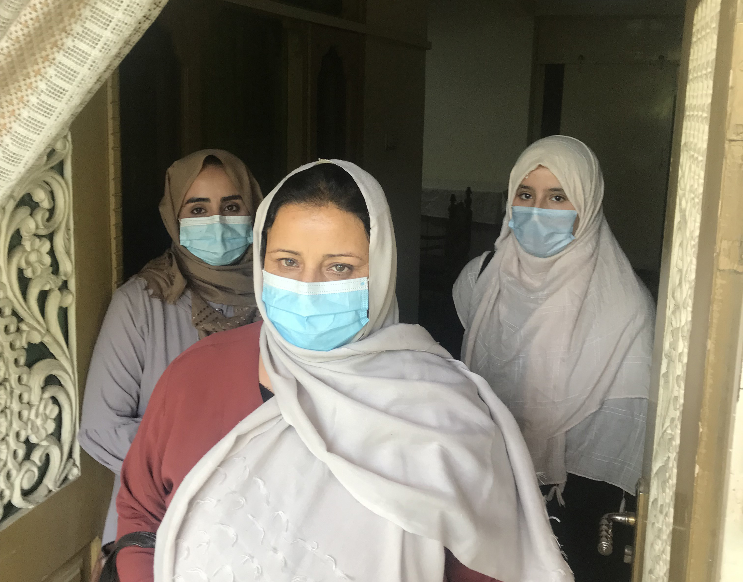 Shima Sadat, principal of the Mohammad Agha District school, stood in front of a teacher and student at the school in Logar Province, Afghanistan,