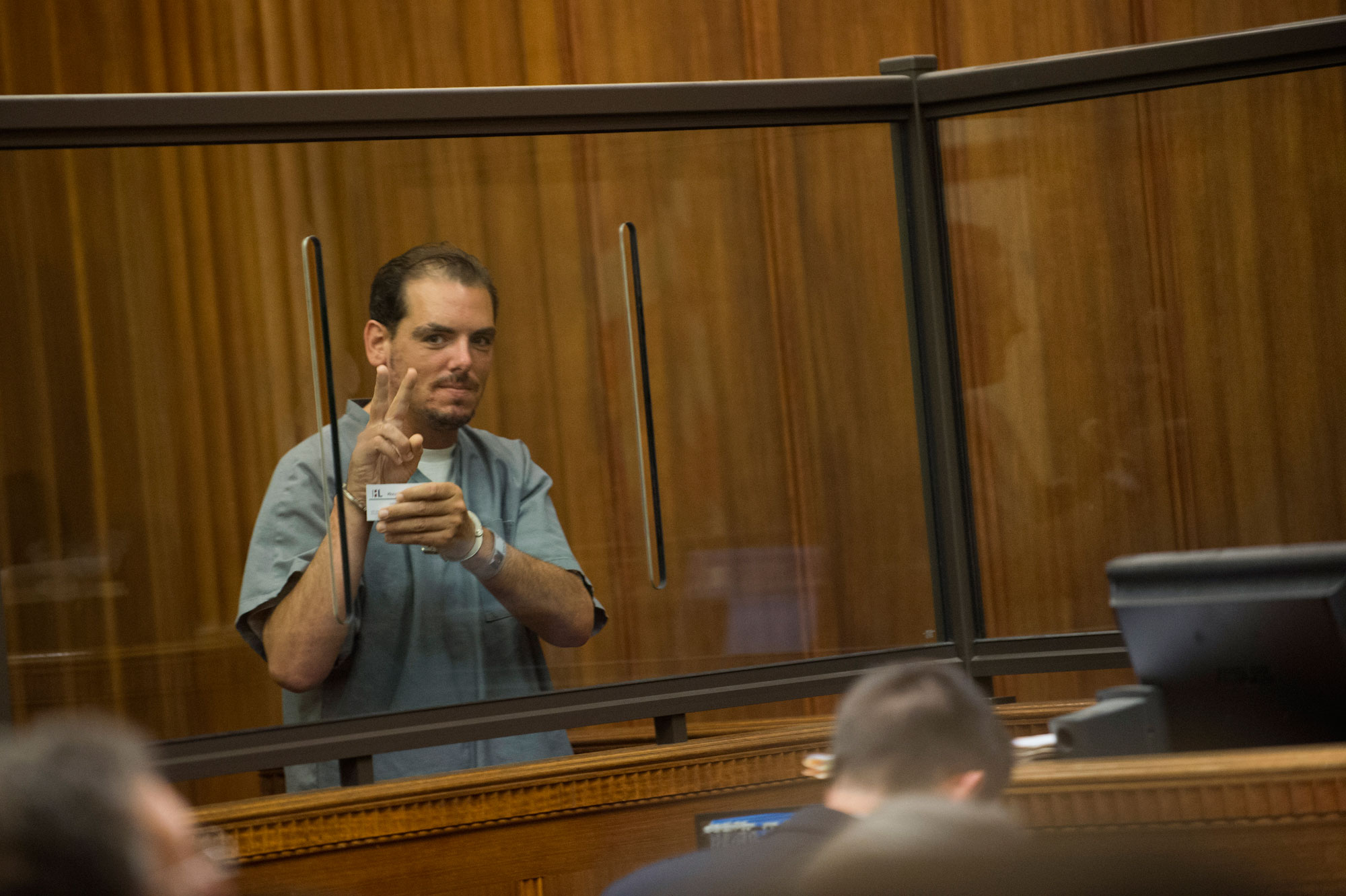 Michael Bourne gave the peace sign to his family during an arraignment in Dedham.