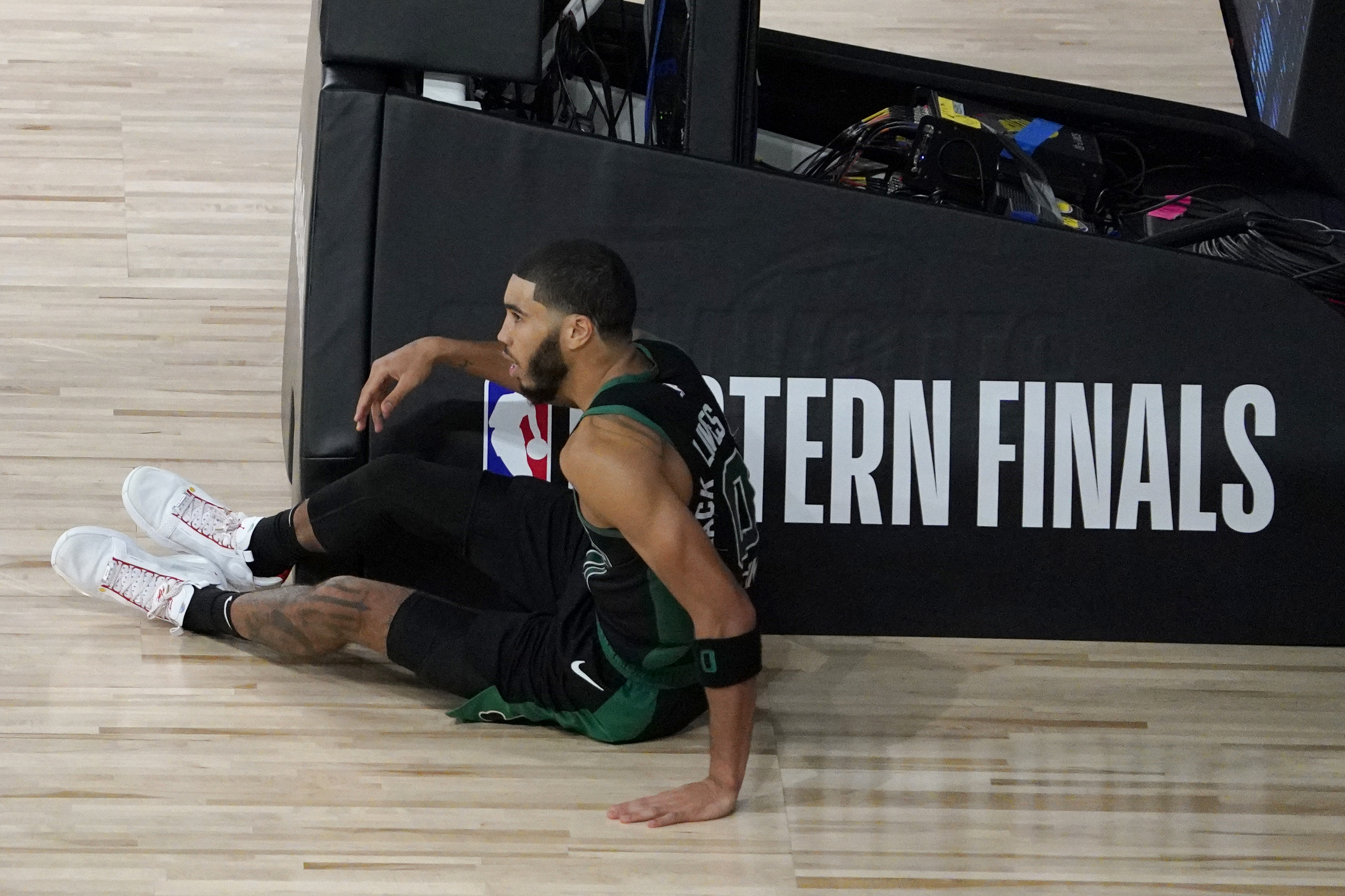 Jayson Tatum sits on the floor after his dunk attempt in OT was blocked by Bam Adebayo.