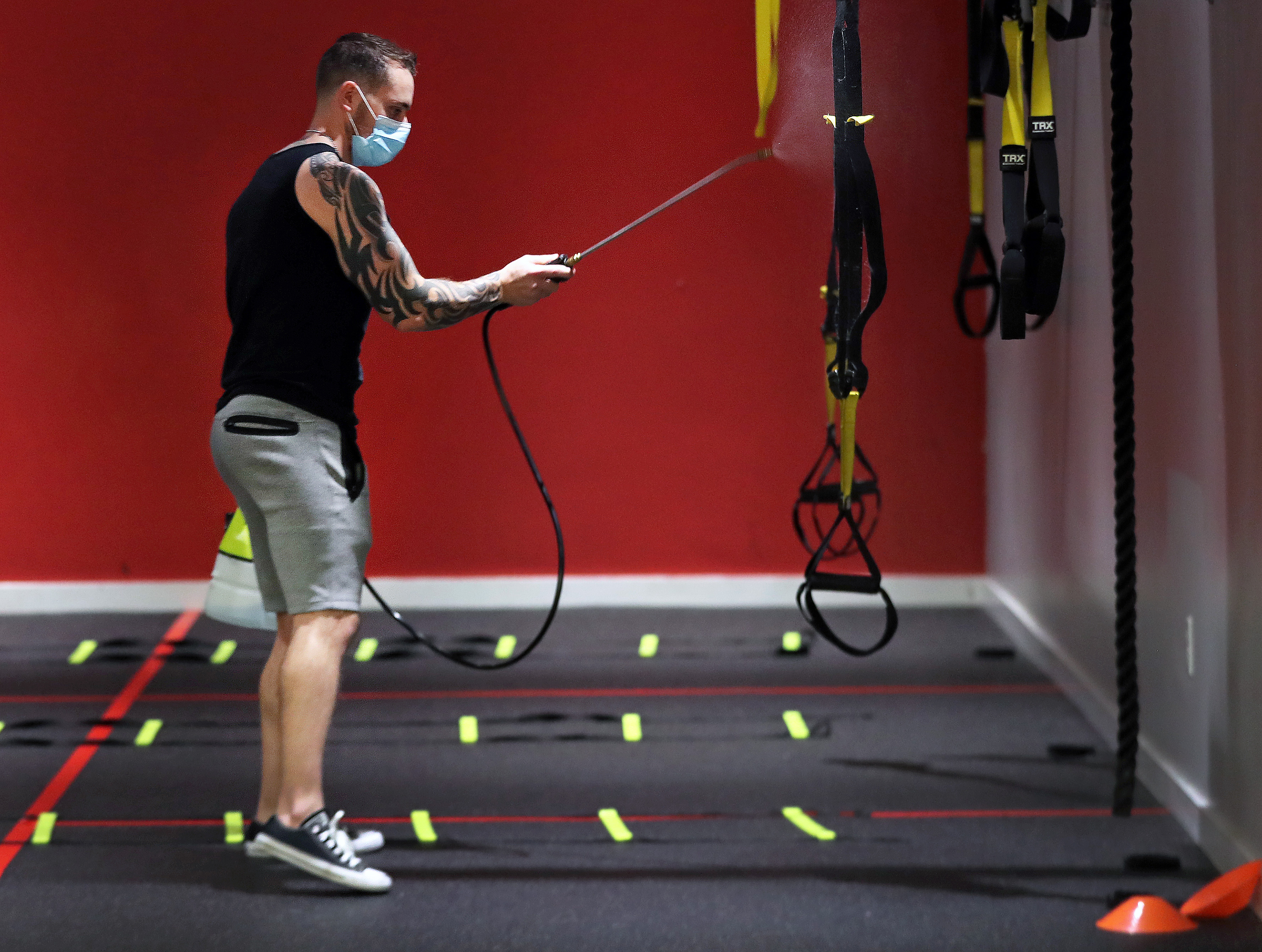 Domenic Prisco, co-owner of Fitness Within in Reading, sprayed all the surfaces with a cleaning solution in between classes at the gym on Tuesday.