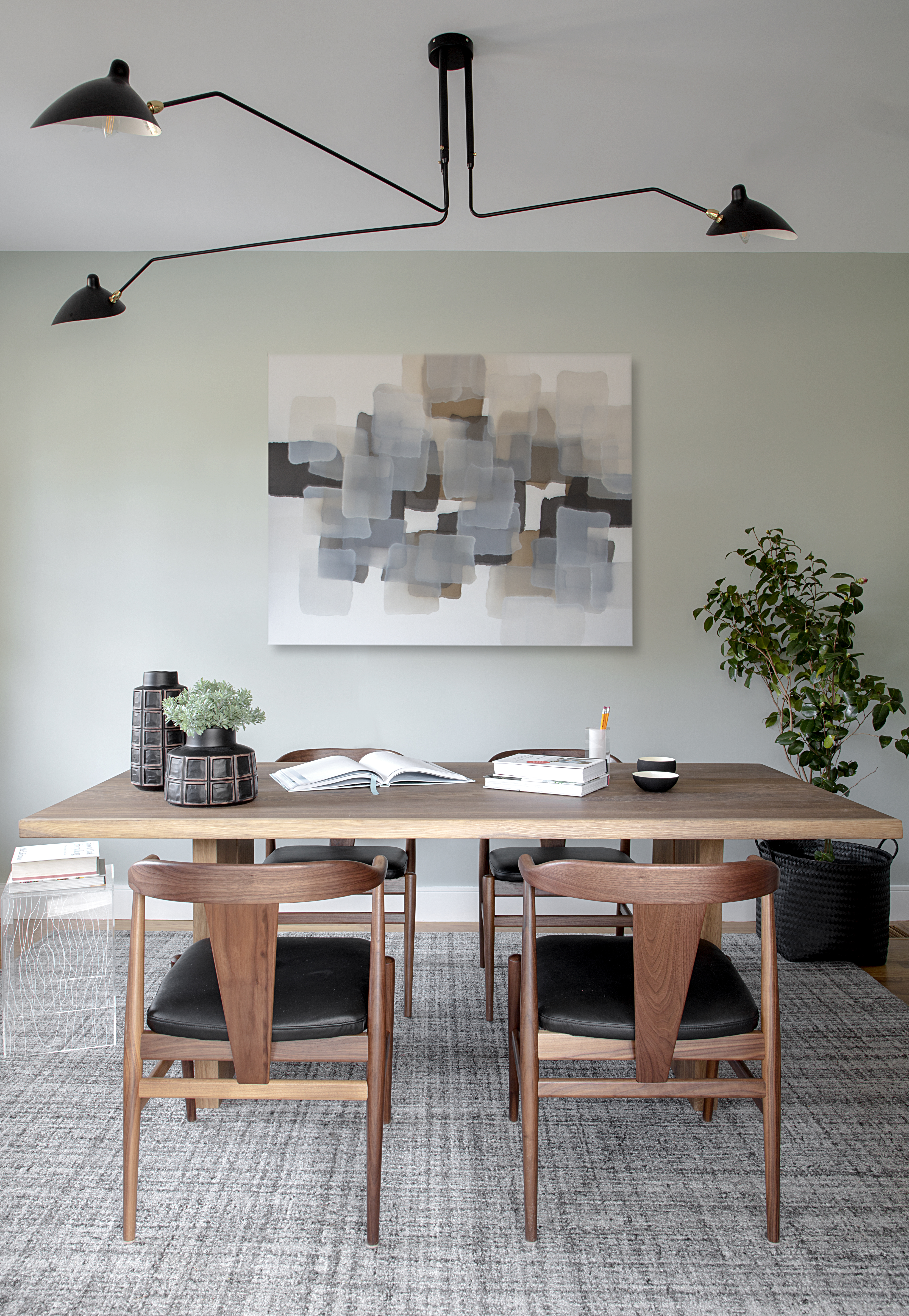 Homeowner Jeremiah O’Connor’s family enjoys his office space during off-hours. The walls, painted Sherwin-Williams Contented, relate to the dark green color used elsewhere in the home. The Charlie Bluett painting was sourced by art consultant Libby Silvia.
