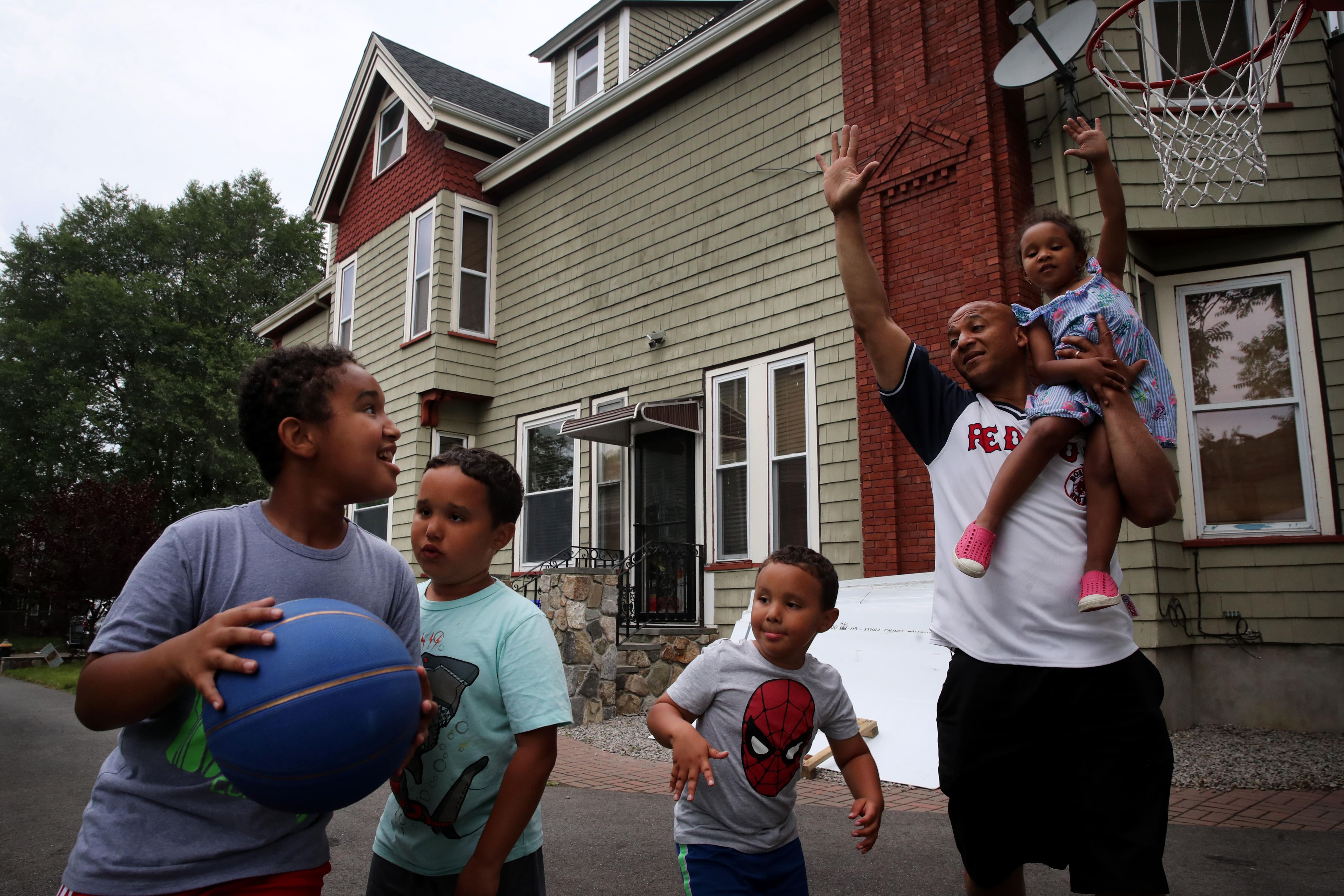 Mayoral candidate John Barros held his daughter, Olivia (right) while playing basketball with his children, (left to right) John Jr., Jeremiah, Casey, at their home in the Dorchester.