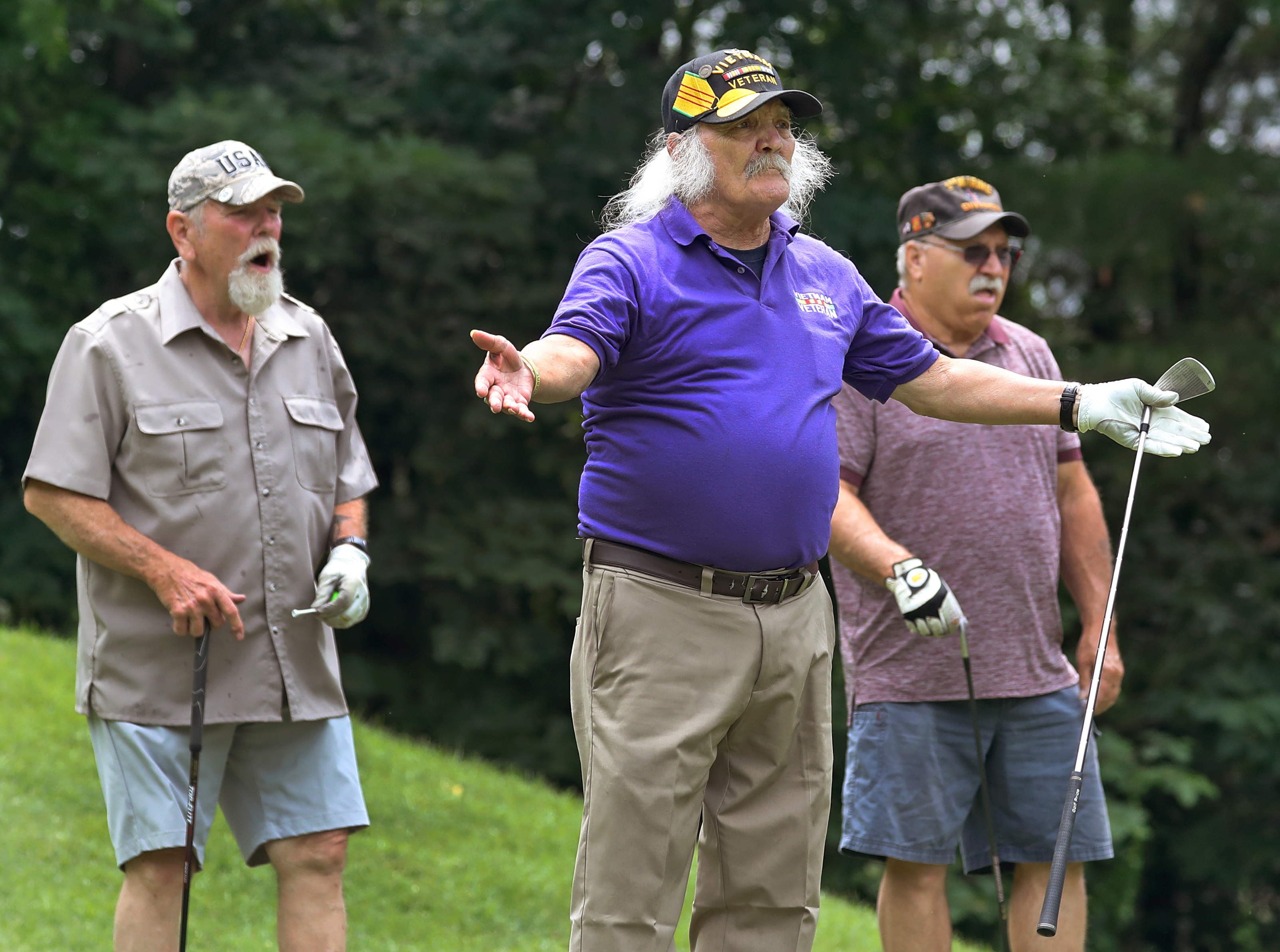 Rich Deneka, 72, right, looks on as Peter "Owl" Giove, 73, center, watches his golf ball fly down the fairway with Armand Sayers, 75.