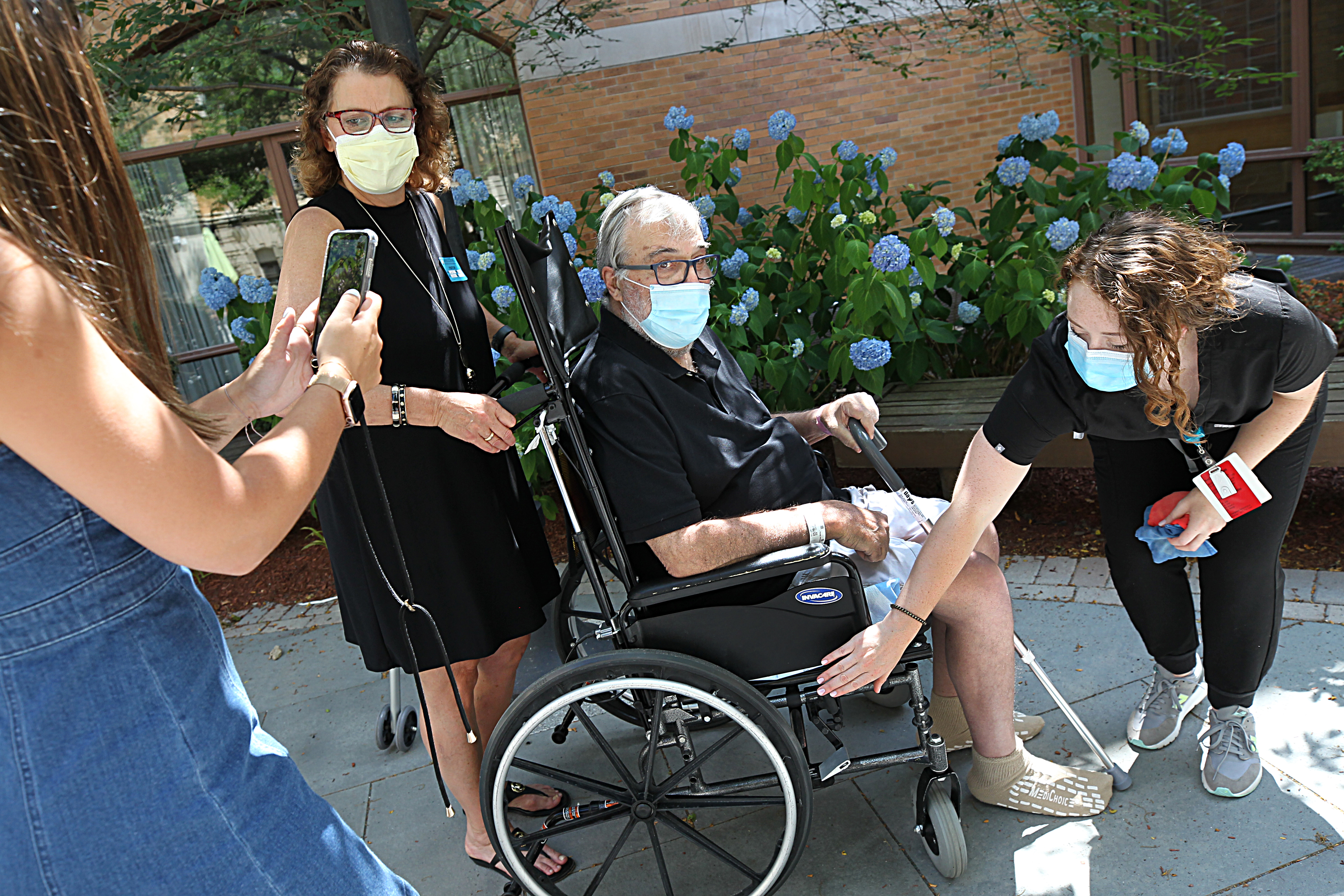 Frank Cutitta took a break during physical therapy at Spaulding Hospital Cambridge. His occupational therapist, Brigid O'Rourke, locked his wheelchair while his daughter Genna, (far left) took a video of his walking which she had not seen yet, and his wife, Leslie, visited him.