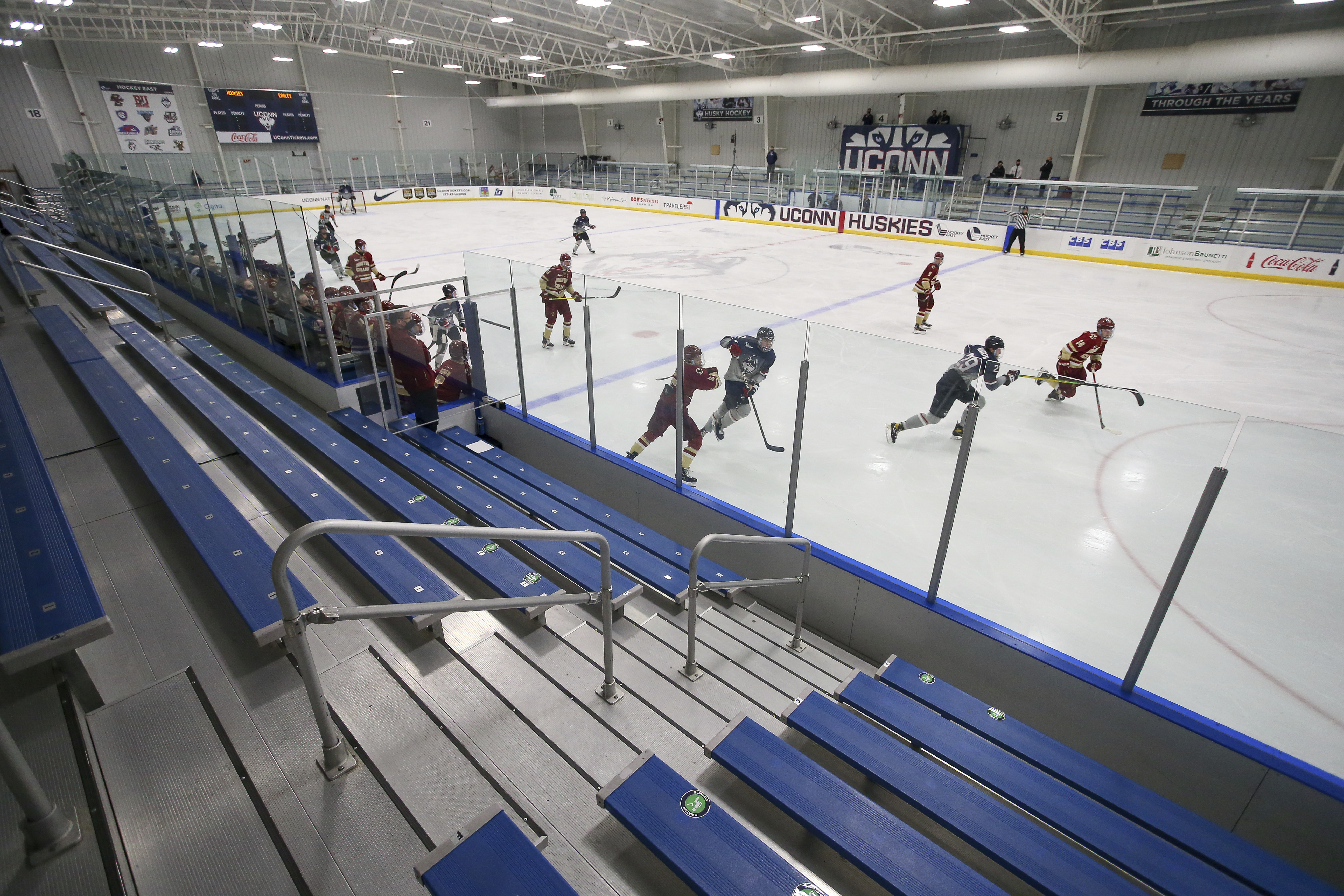 Boston College and Connecticut play an NCAA hockey game in an empty arena on Saturday, Dec. 12, 2020, in Storrs, Conn. This season, the stands are slated to be open to spectators.