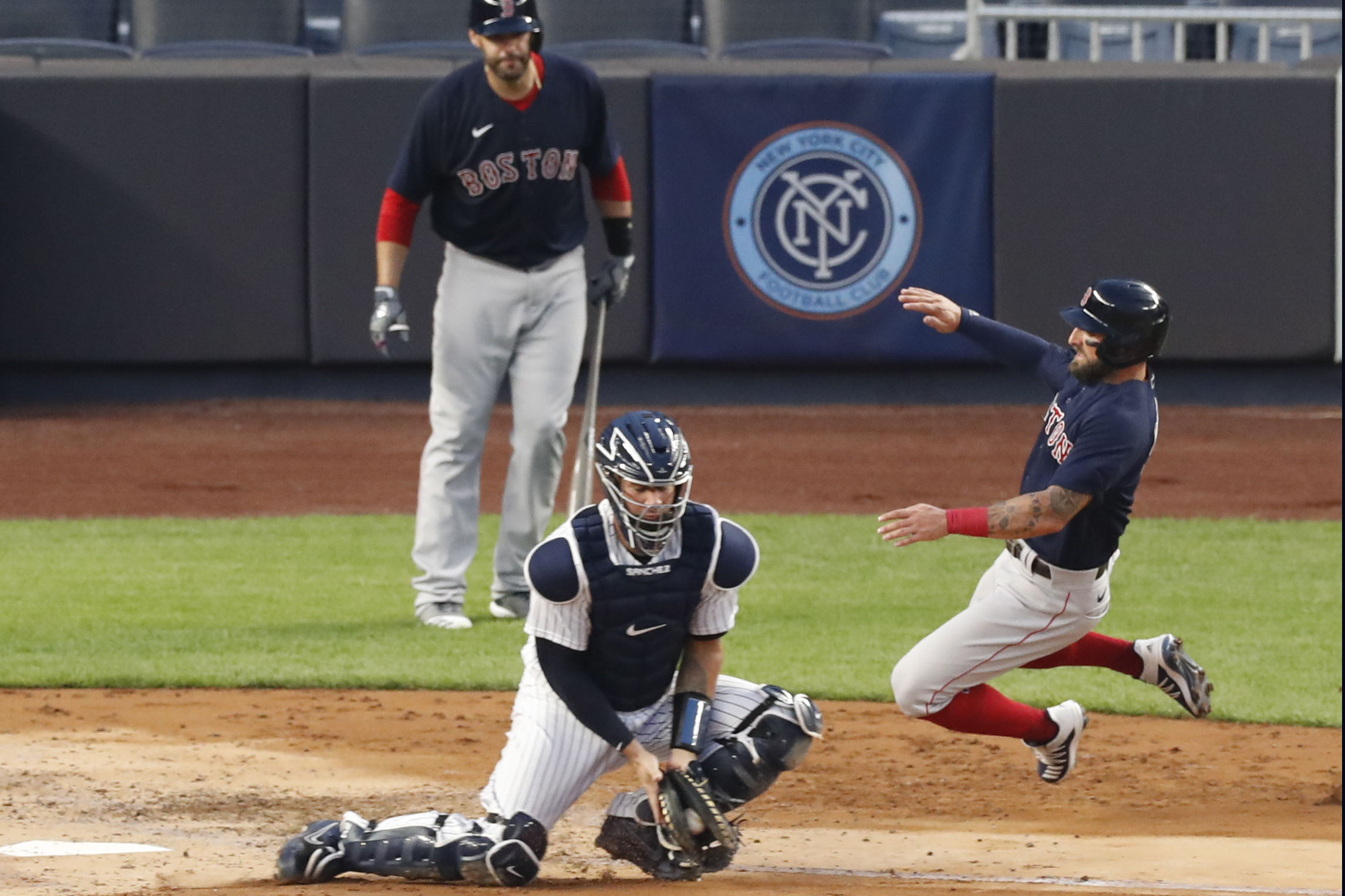 Kevin Pillar, right, scores ahead of the throw to catcher Gary Sanchez during the third inning of Sunday's game.