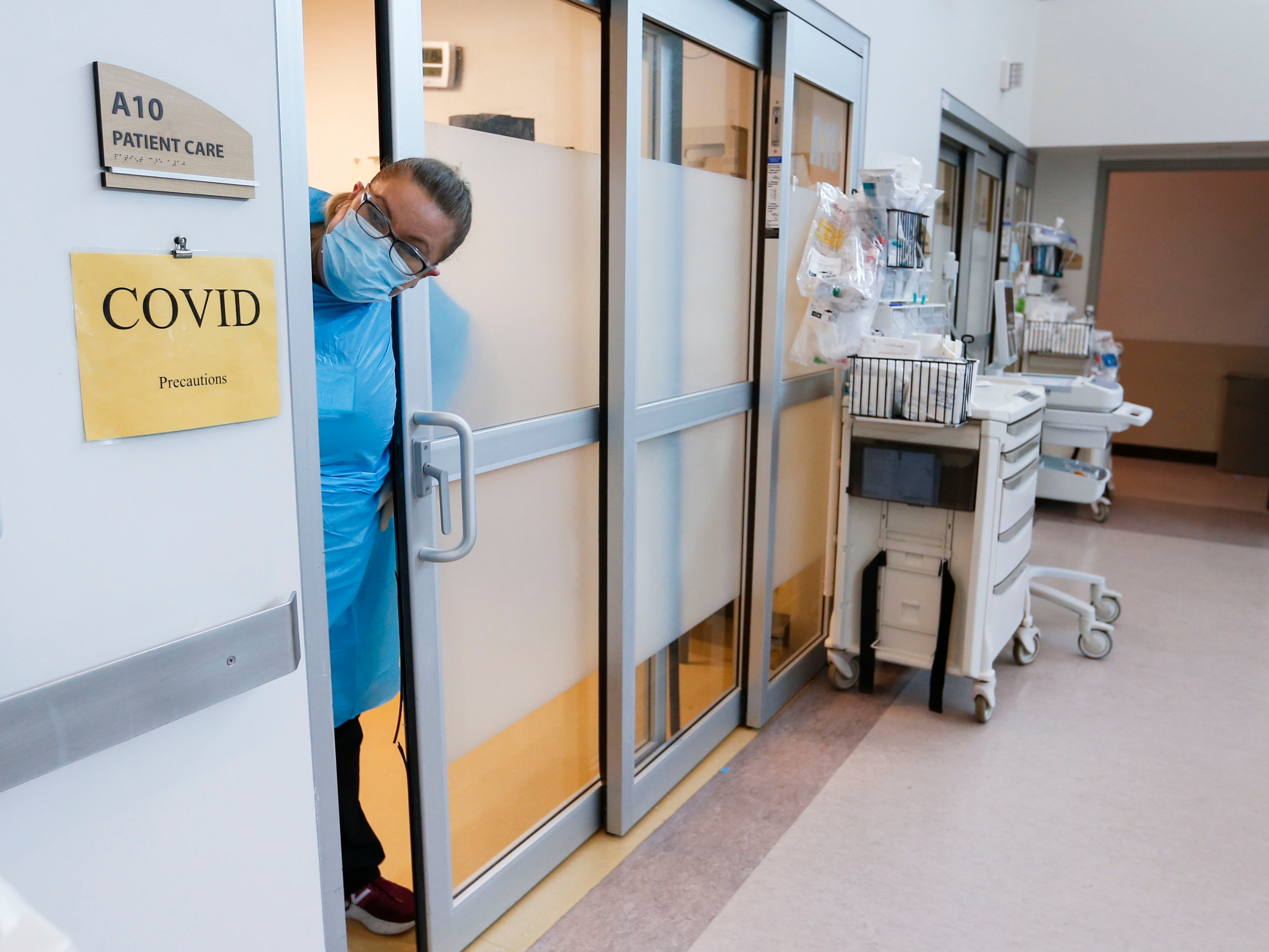 A nurse peered out from the room of a COVID-19 patient in the CoxHealth Emergency Department in Springfield, Mo., this month.