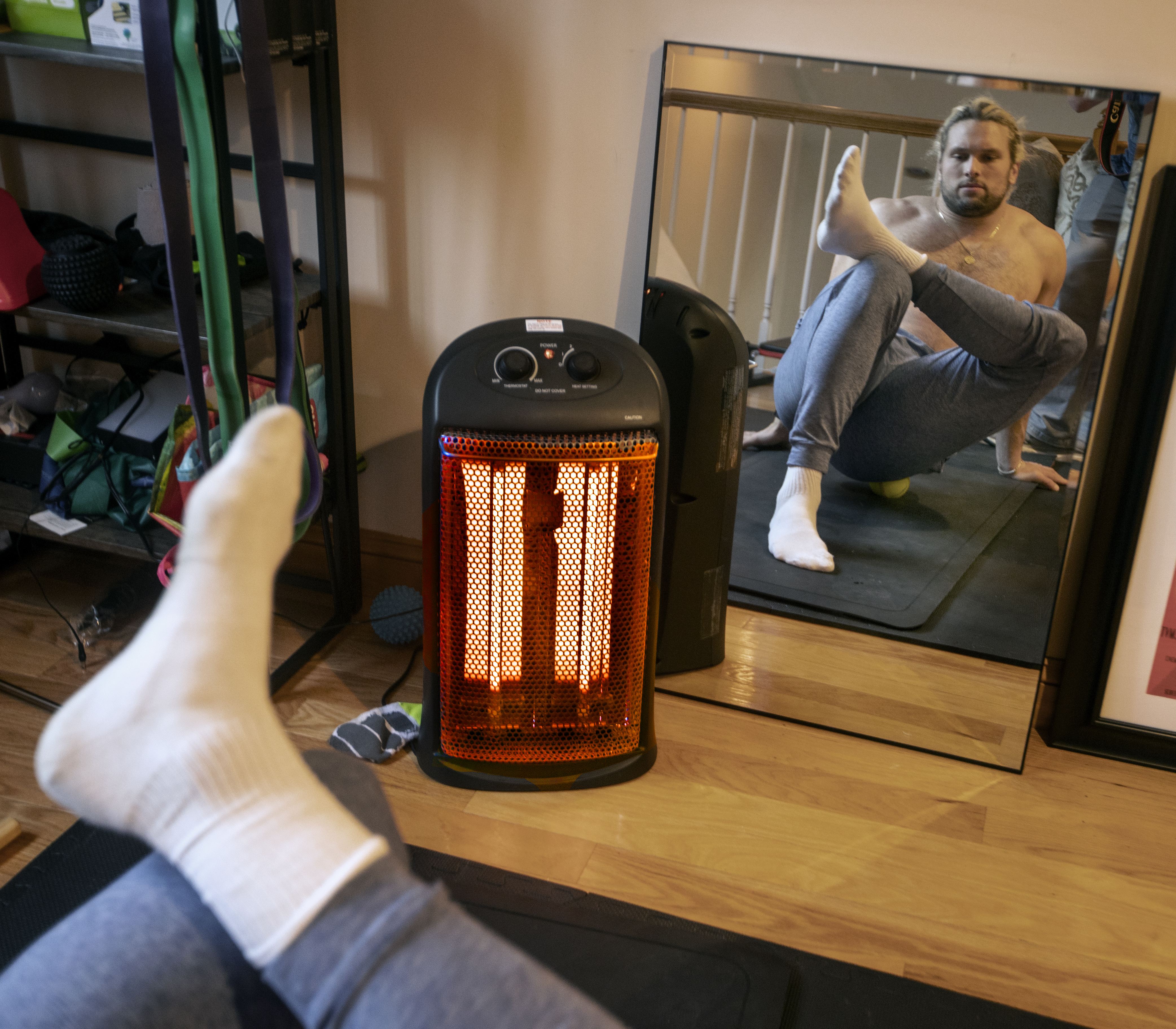Chase Winovich executes a yoga pose in front of a space heater in his home.